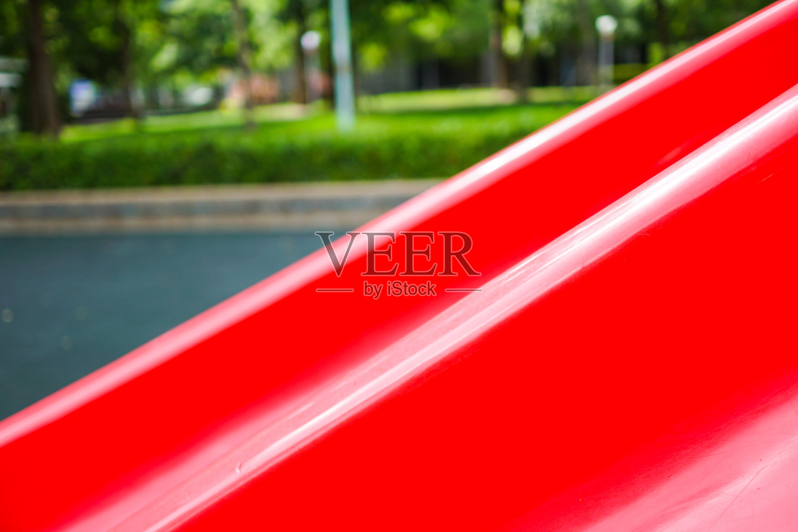 红色滑梯的特写。五颜六色的儿童游乐场。公园里的游乐设备。主题在右边。照片摄影图片