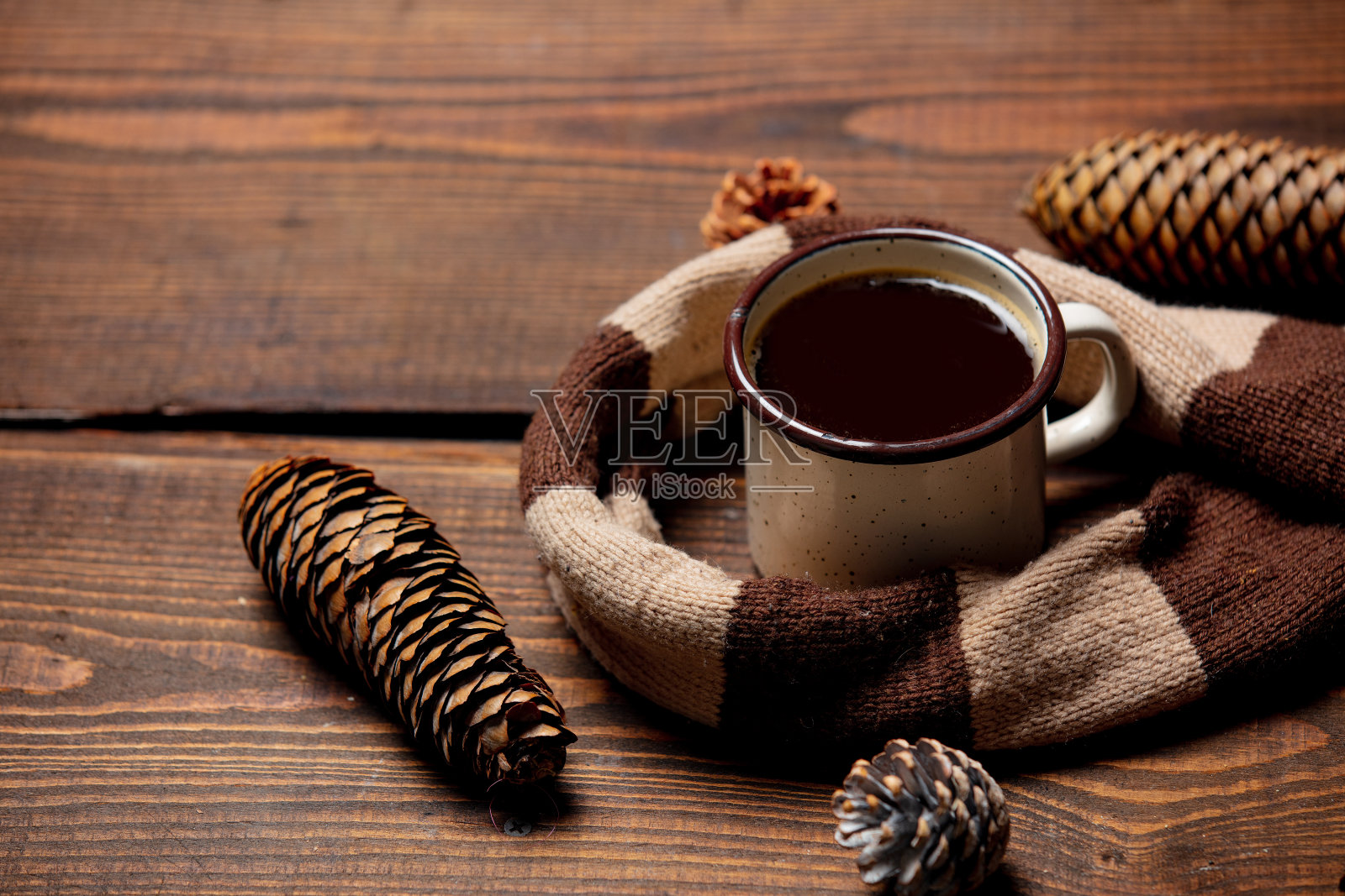 木桌上放着一杯咖啡和一条围巾照片摄影图片