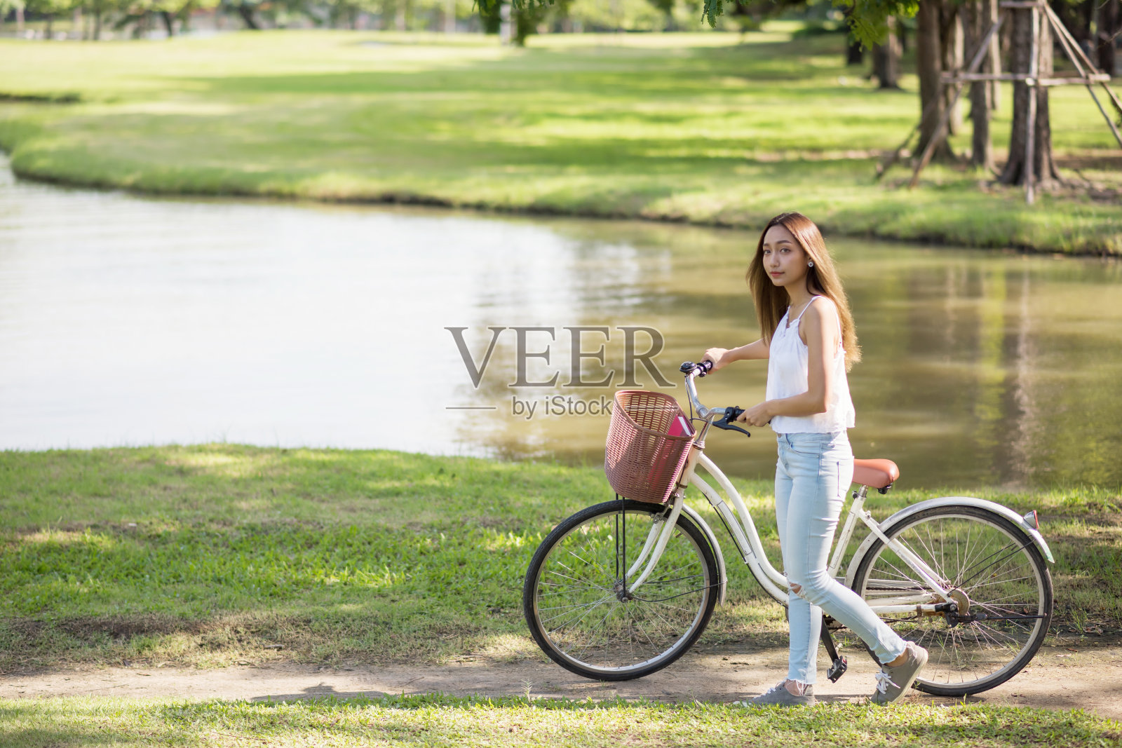 美女在市区公园的池塘里散步照片摄影图片