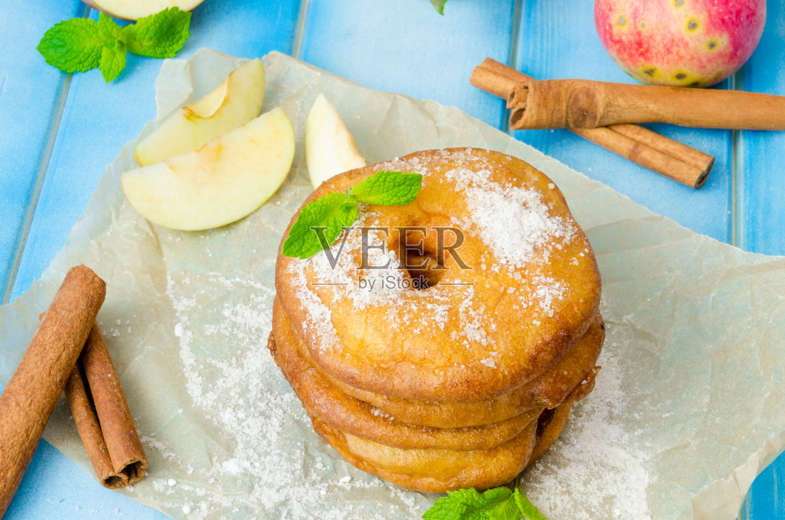 在面糊中与肉桂和糖粉一起油炸的苹果照片摄影图片