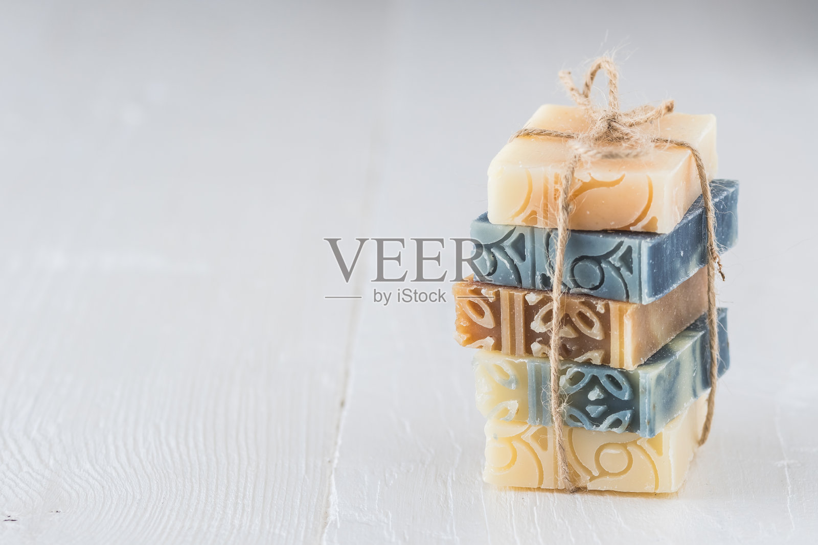 堆叠各种天然肥皂条在白木。带有复制空间的库存照片。照片摄影图片