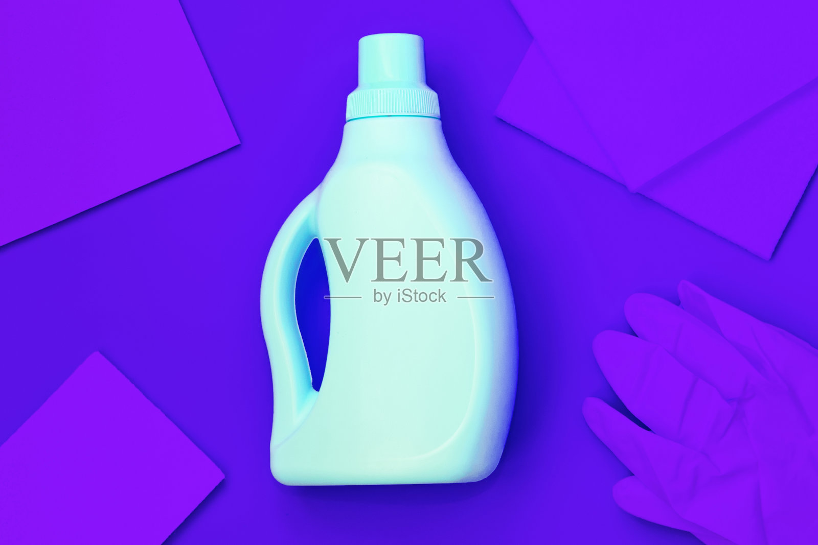 蓝色的瓶子在中间，深蓝色的破布，深蓝色的手套在深蓝色的背景上。清洗的概念照片摄影图片