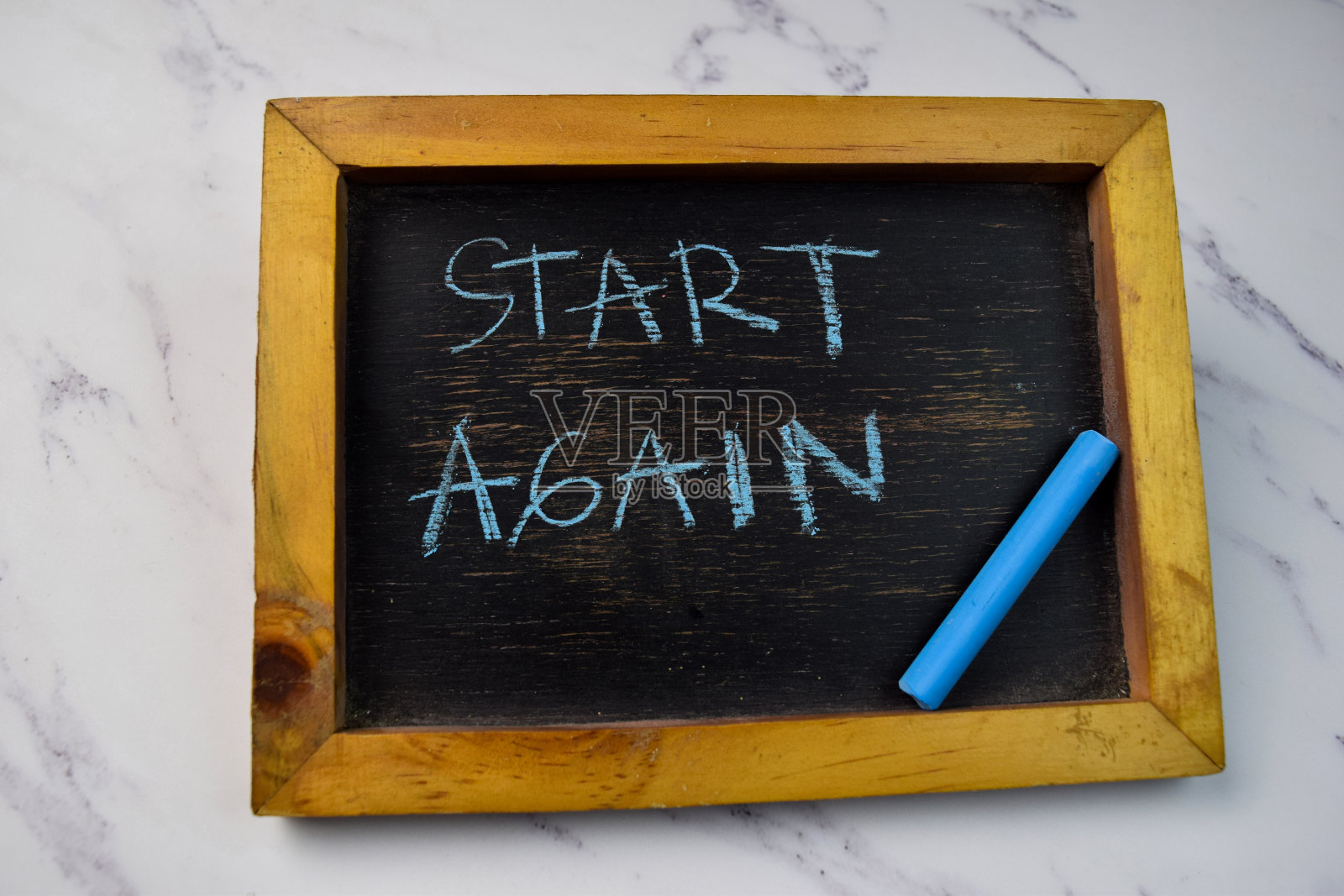 开始在黑板上写字，把黑板隔离在木桌上。照片摄影图片