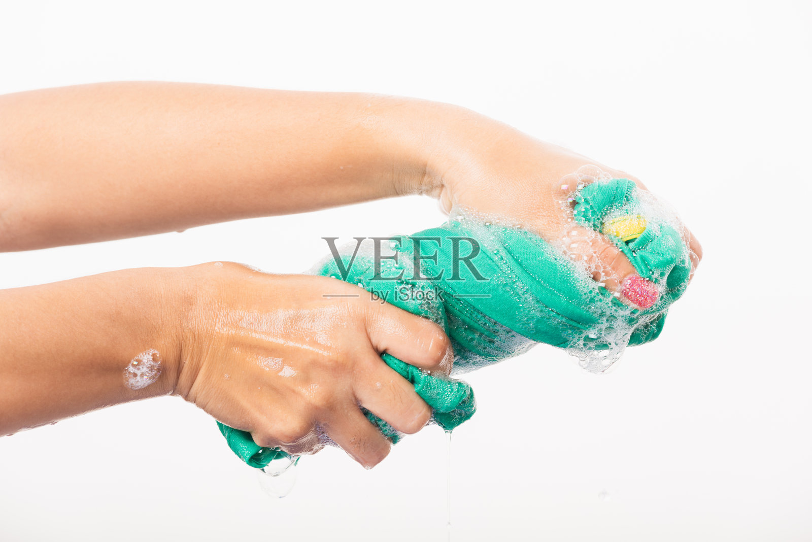 女挤拧湿布布用洗涤剂有肥皂泡沫的水照片摄影图片