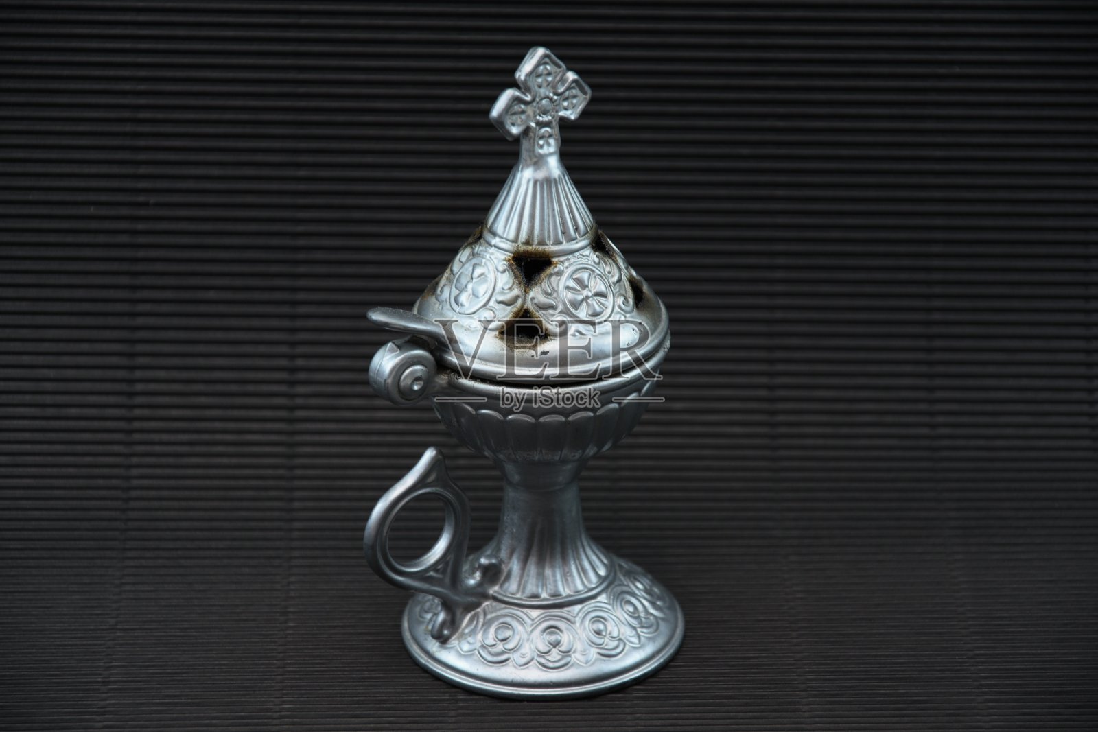 黑色背景上有十字的青铜香炉照片摄影图片