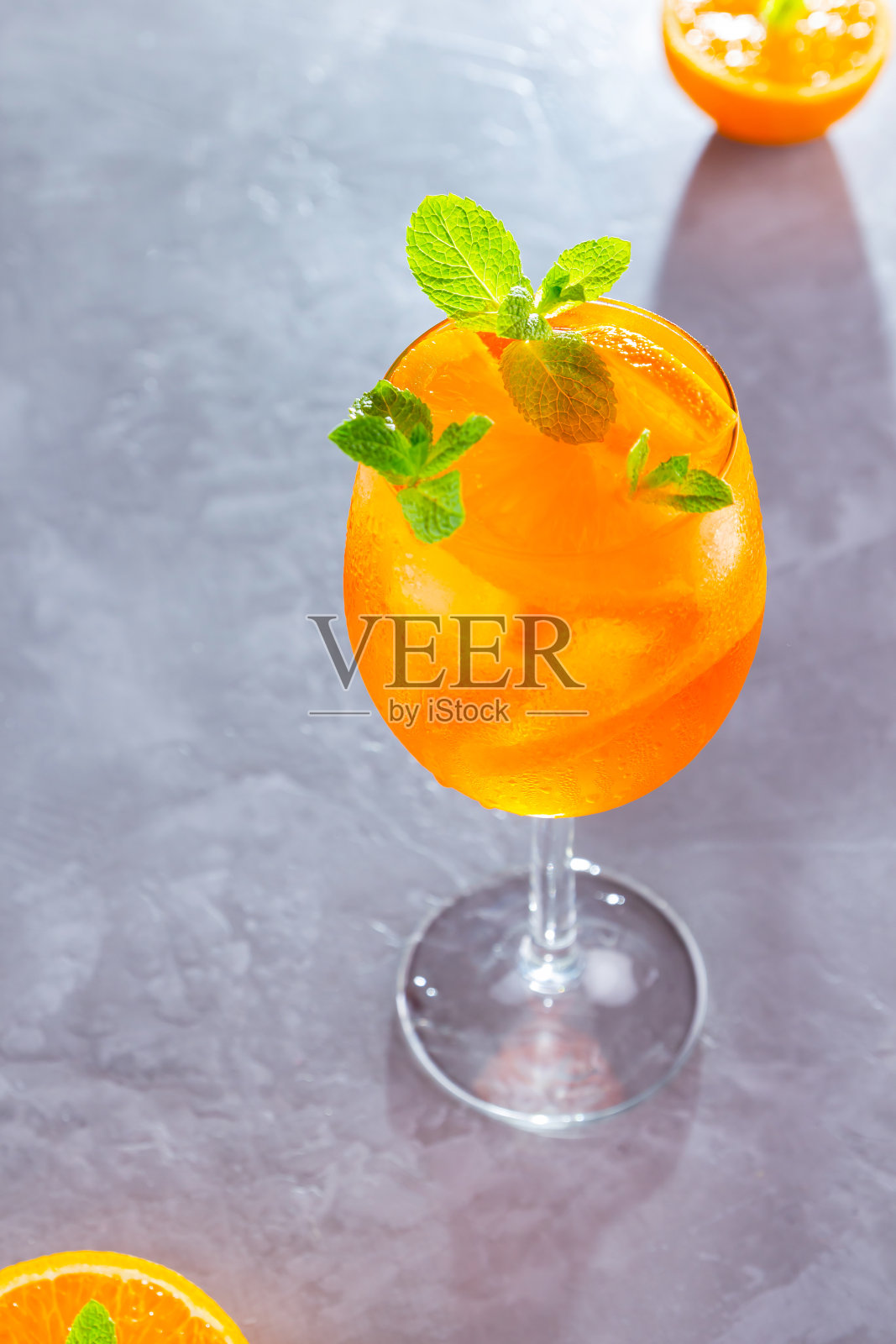 灰色背景上的鸡尾酒喷雾。一杯加橘子片的喷雾。夏日鸡尾酒。前视图。本空间照片摄影图片