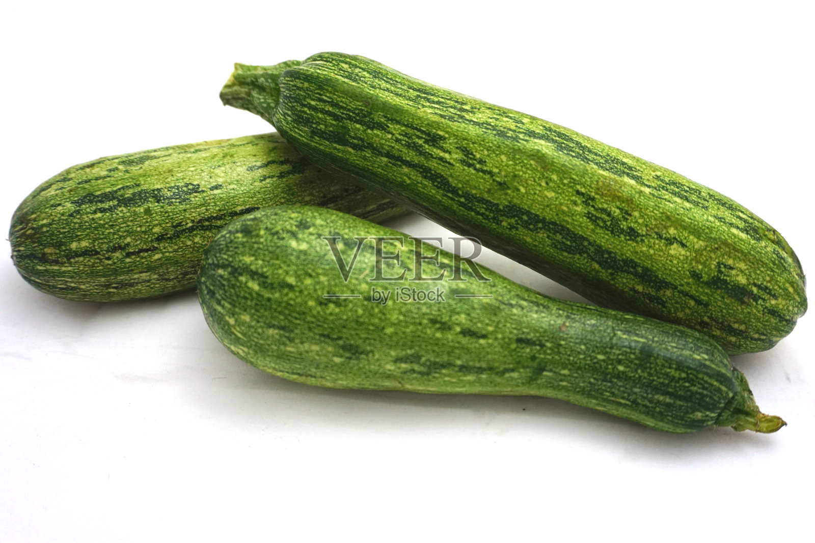 三个西葫芦，白色背景上的整个绿色西葫芦照片摄影图片