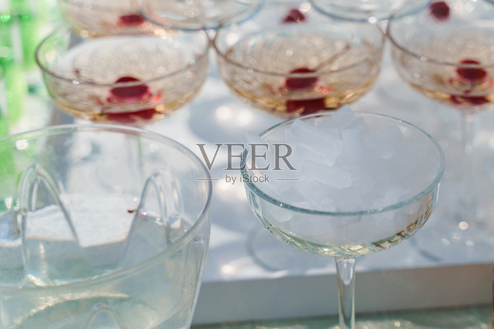 干冰在杯子靠近金字塔的香槟。当服务生将冰块放入起泡酒杯时，会产生烟熏效果。照片摄影图片