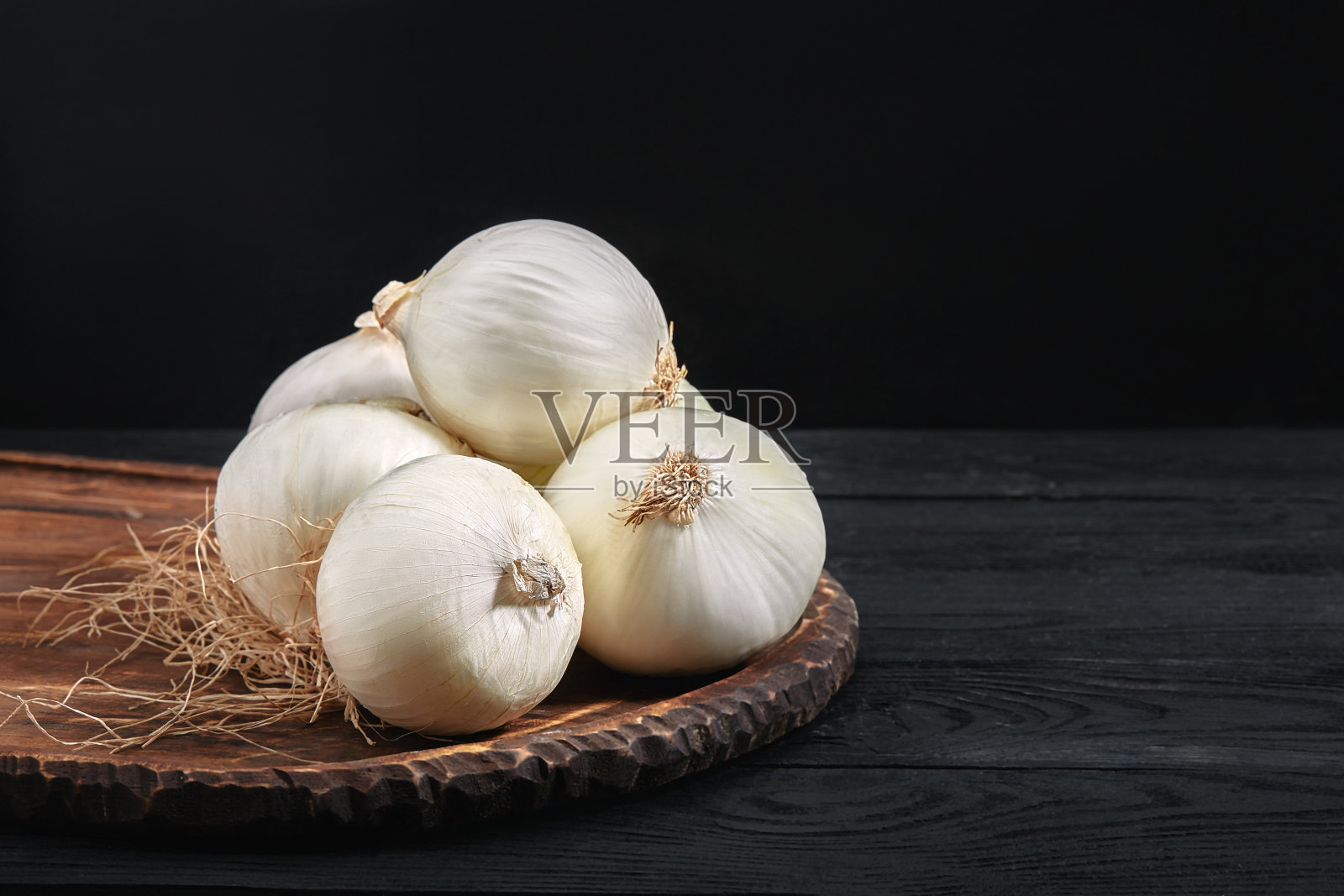 木板上的白洋葱，背景是黑色照片摄影图片