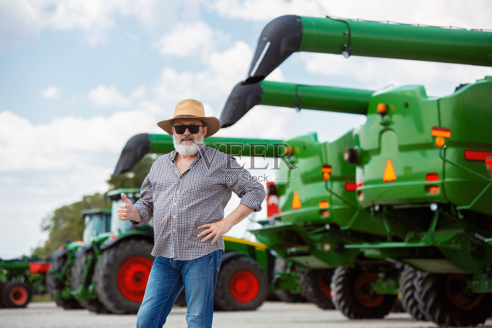 农民开着拖拉机在阳光下犁地。自信,鲜艳的颜色照片摄影图片