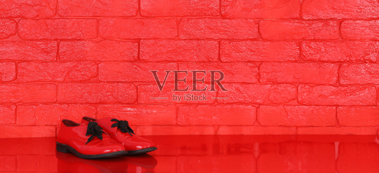 红色的女鞋，红色的砖墙背景照片摄影图片