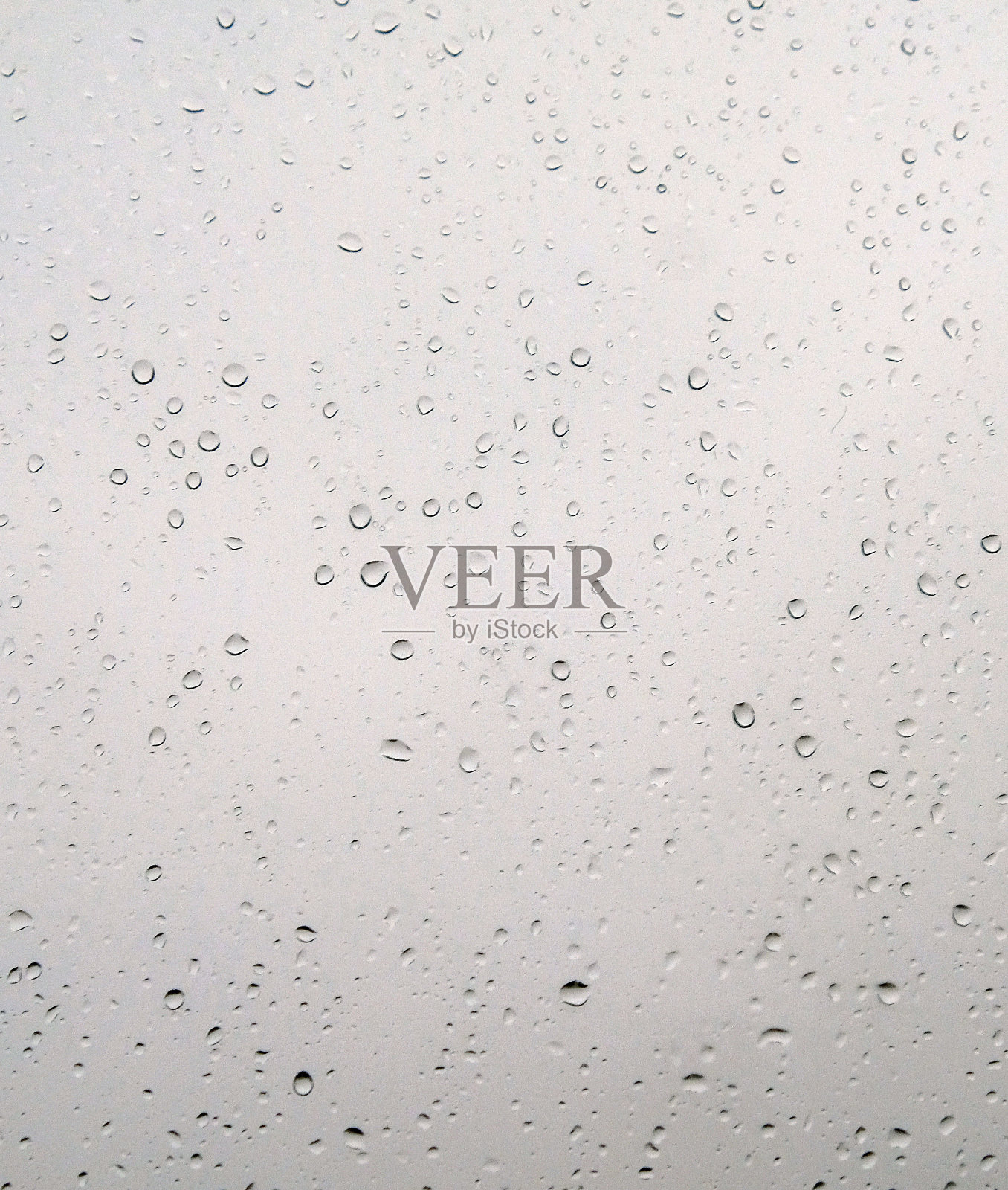 快速流动的雨滴落在玻璃上，移动的雨滴落在挡风玻璃上，照片摄影图片