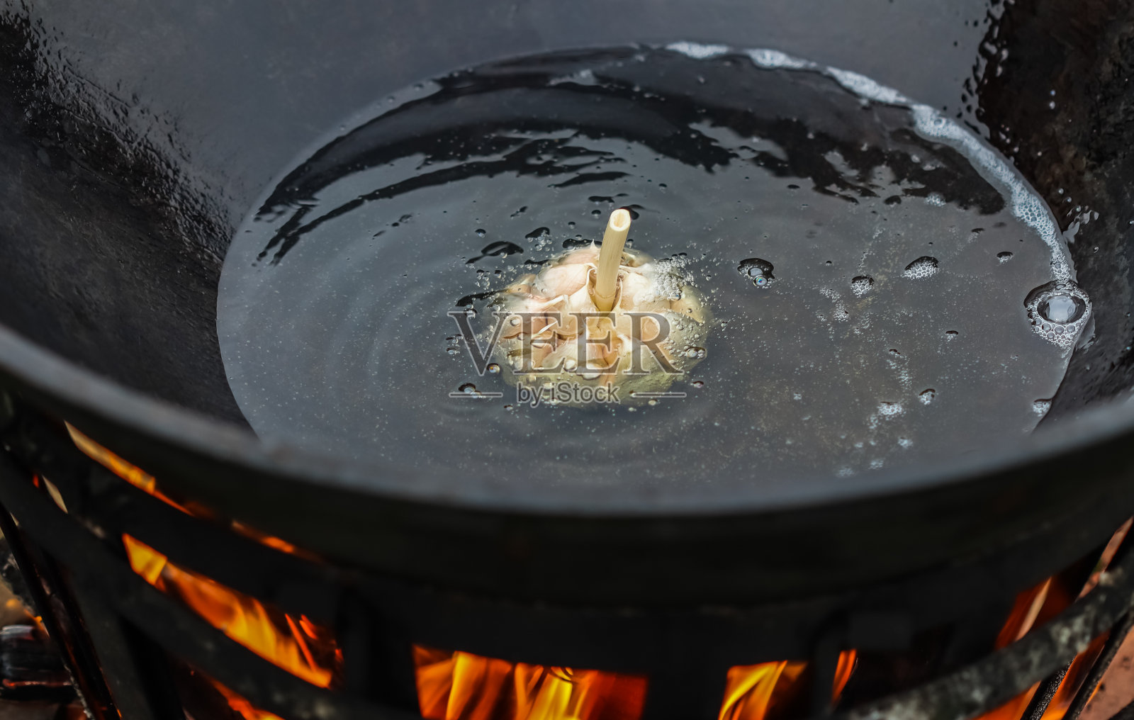 在一个大的铸铁锅里烧饭照片摄影图片