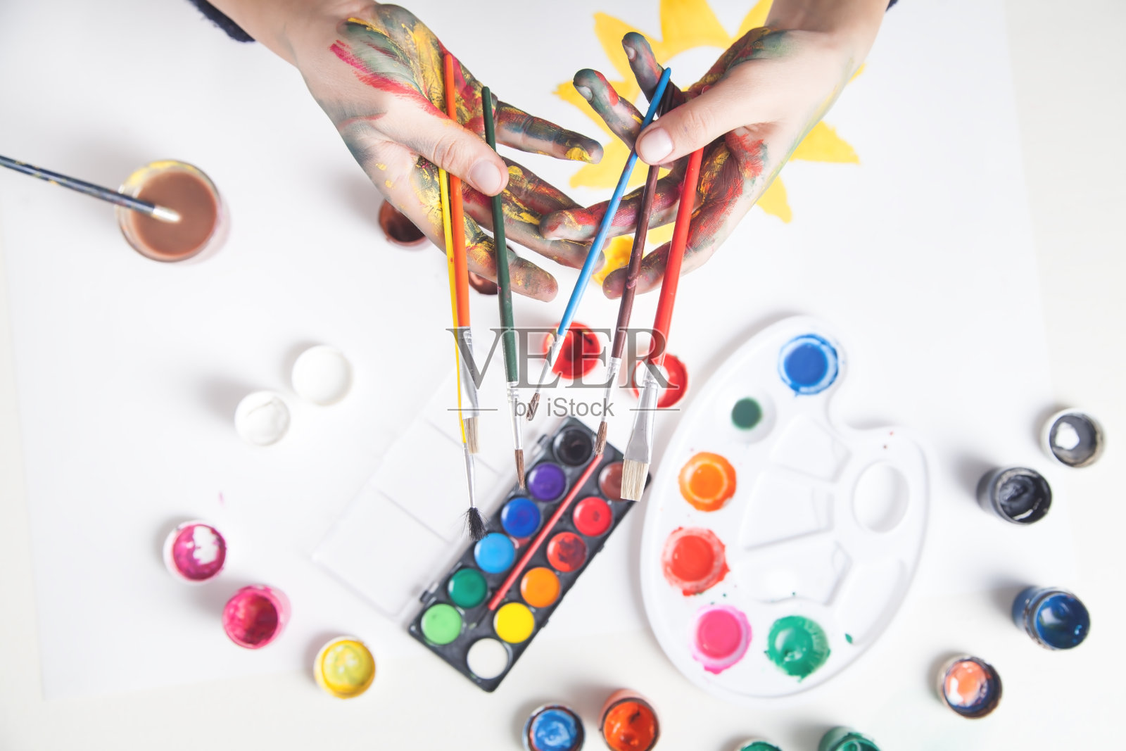 女孩画家拿着很多刷子。照片摄影图片