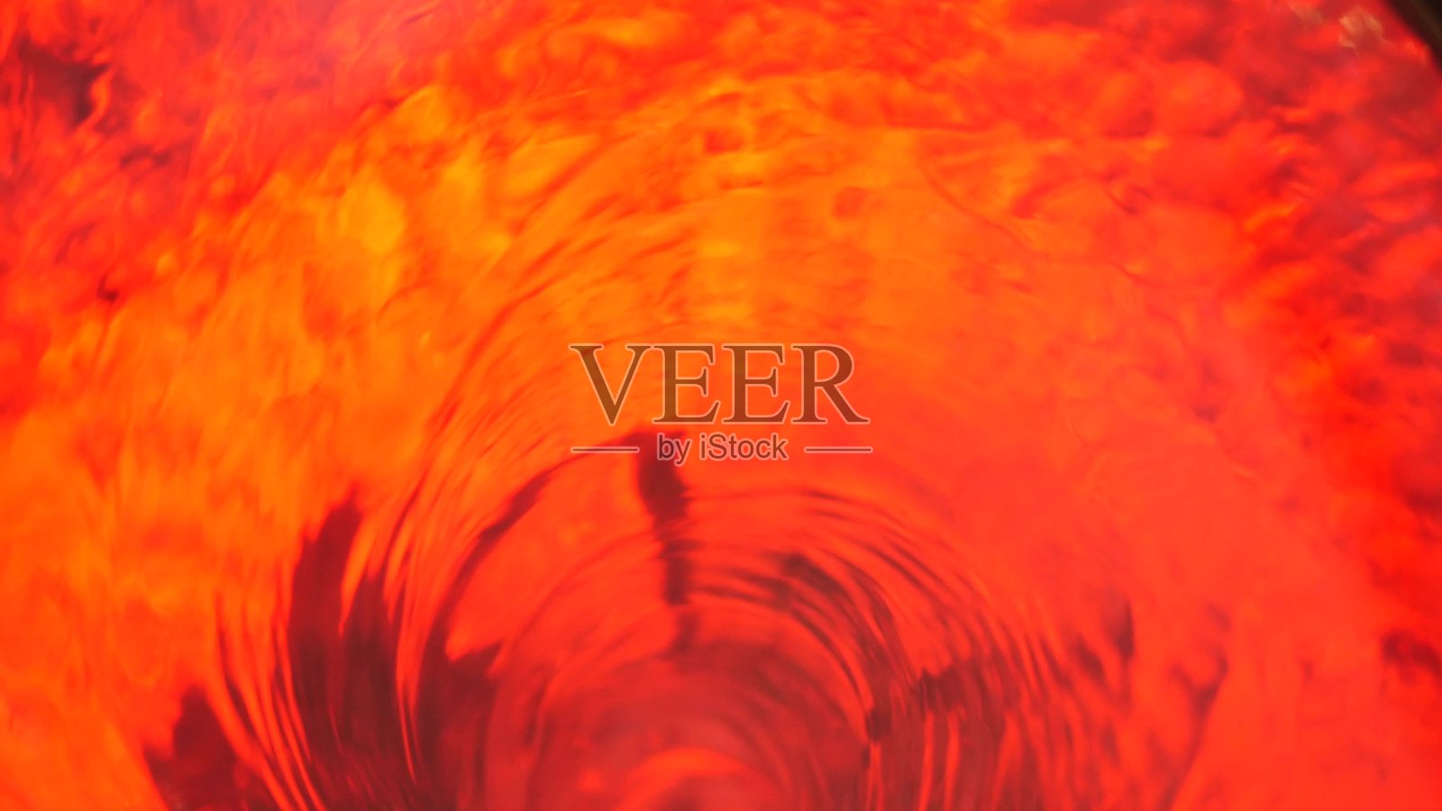 象征着地狱，地狱和无限。红色液体催眠循环水旋转。冥想的发光的漩涡。迷人的水晶流体螺旋隧道。火热的超现实韵律水梯度照片摄影图片