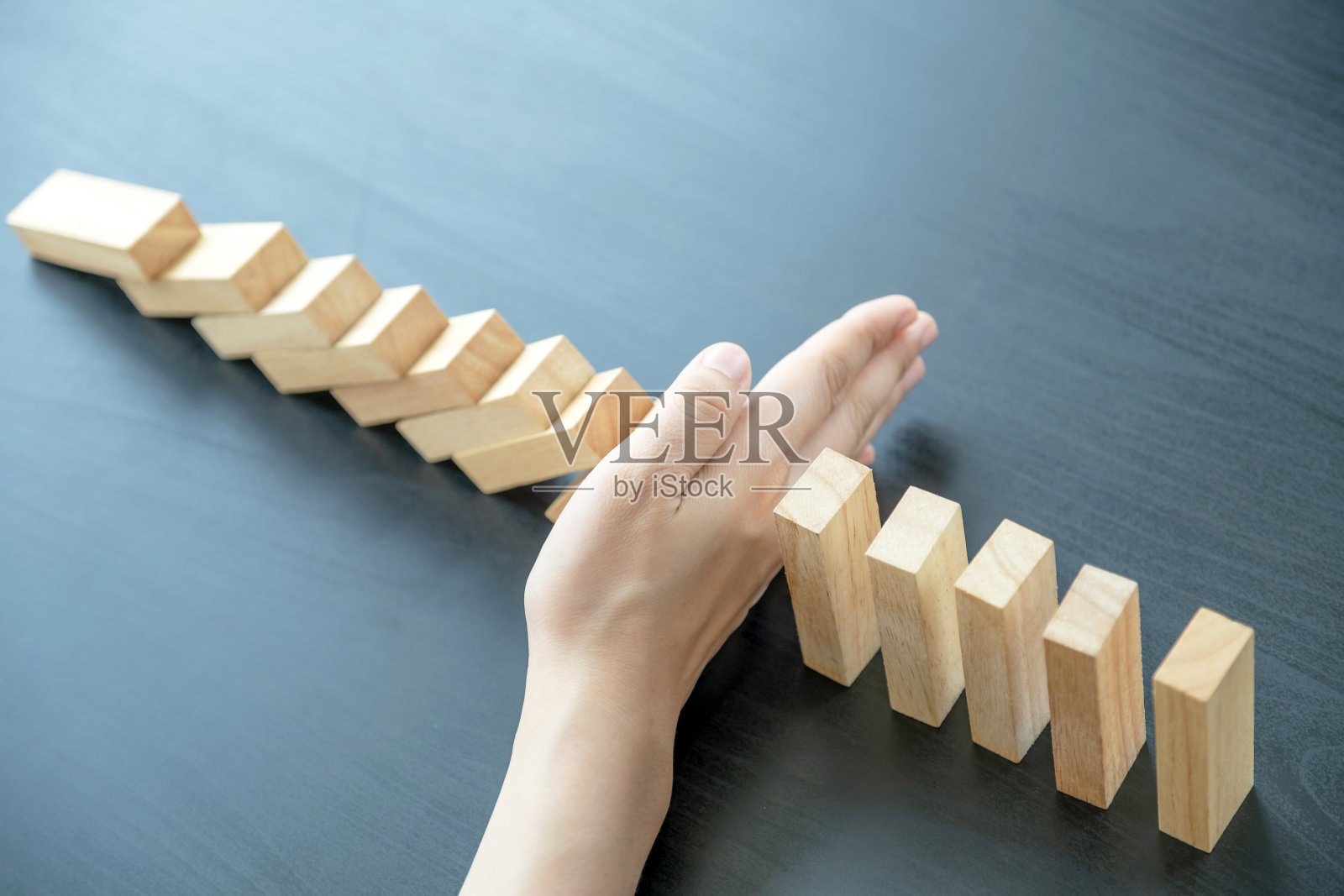 妇女手挡木块用于保护其他木块，概念风险管理和战略规划照片摄影图片