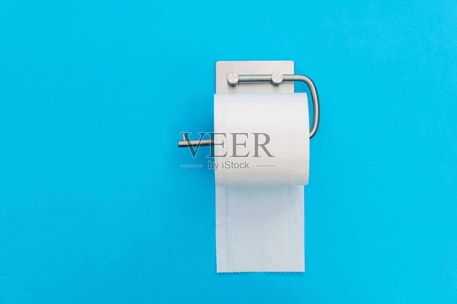 一卷白色卫生纸挂在蓝色背景上照片摄影图片