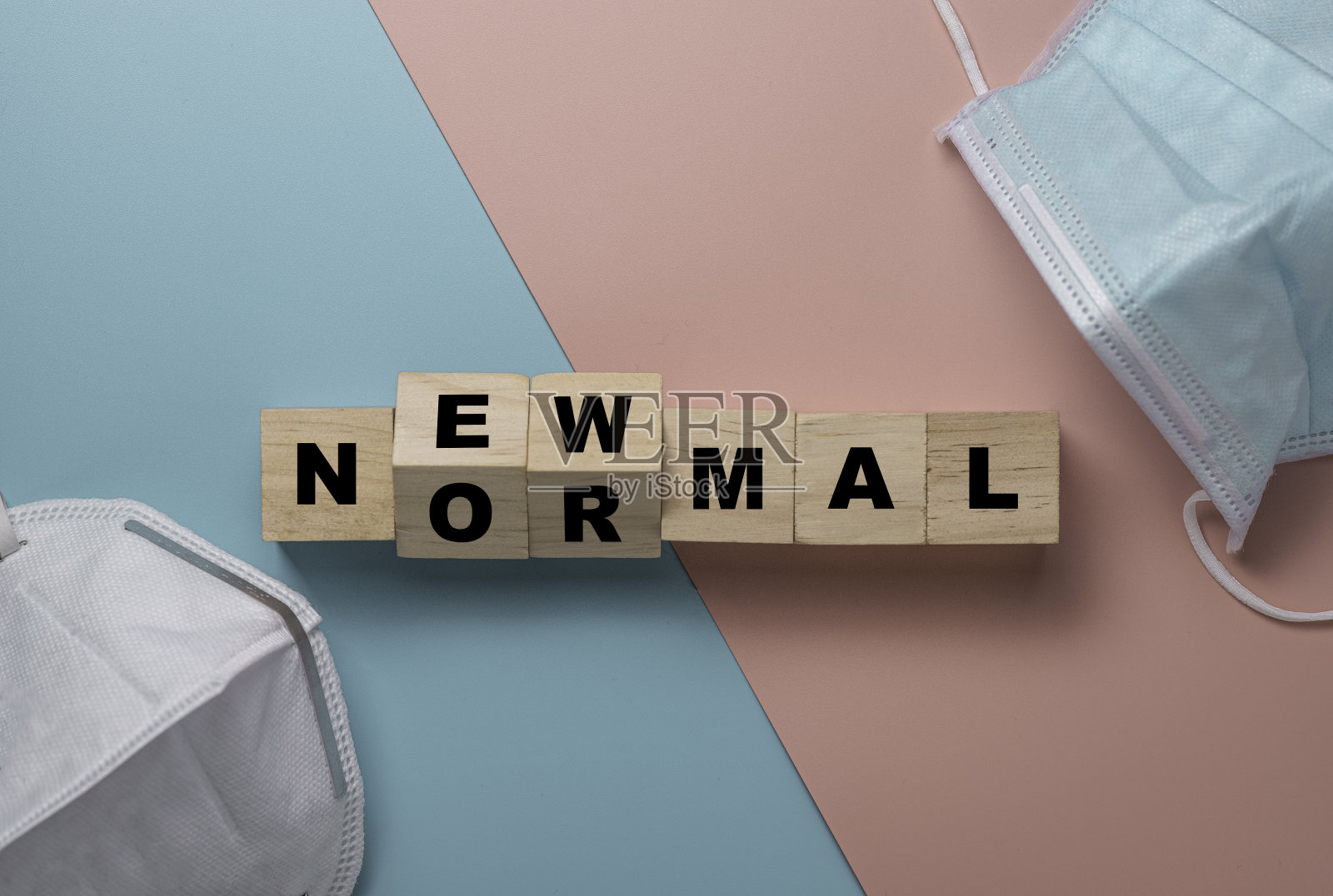 平铺的翻转木块立方体为新的正常用语与外科口罩。世界正在发生变化，以使其平衡成为新的常态，包括商业、经济、环境和卫生。照片摄影图片