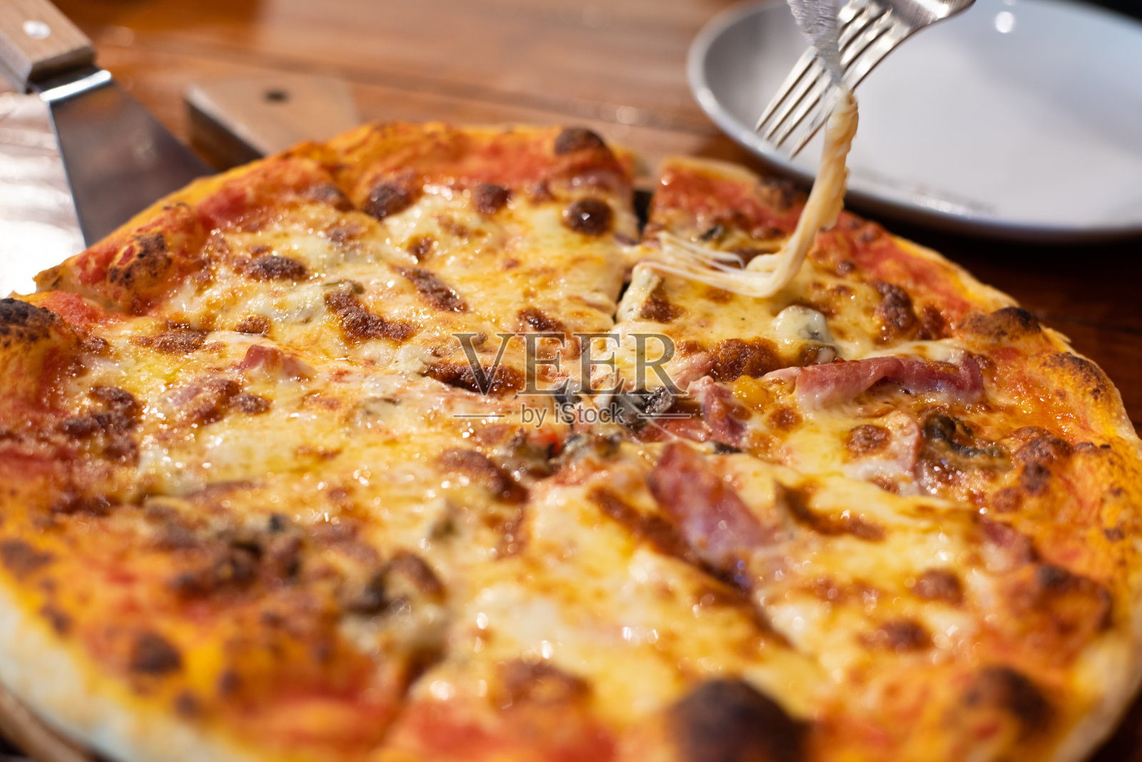 靠近比萨饼在木盘子上。照片摄影图片