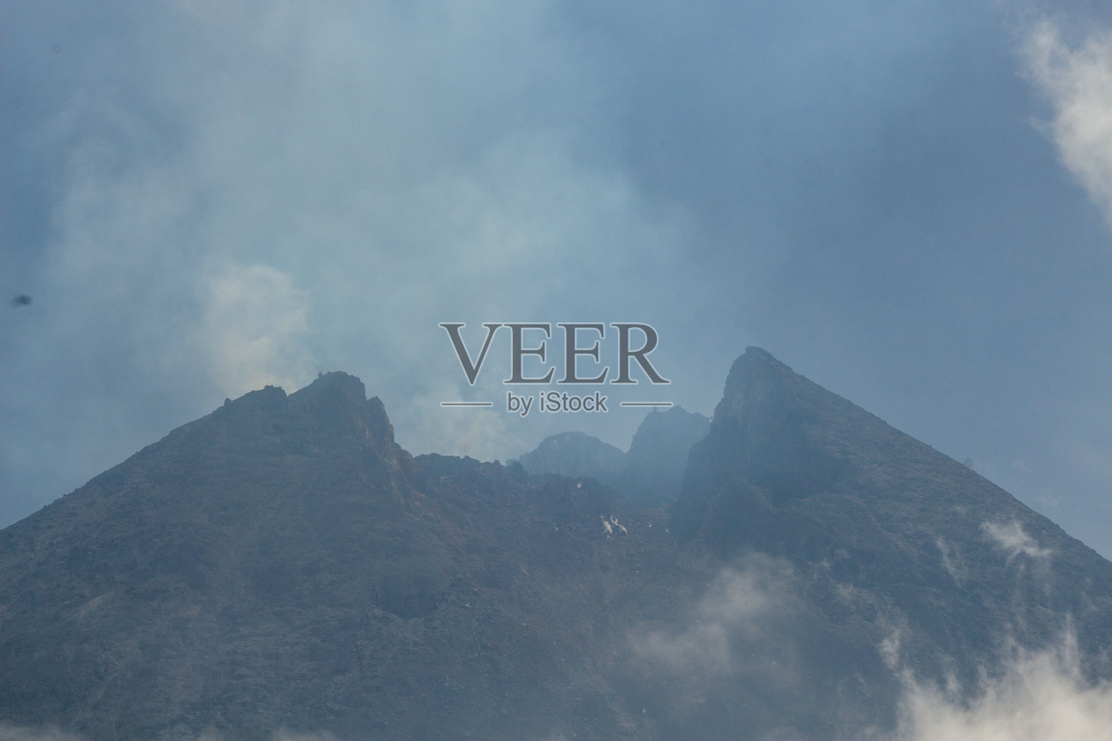 默拉皮火山喷发硫磺气体，周围有几团云照片摄影图片