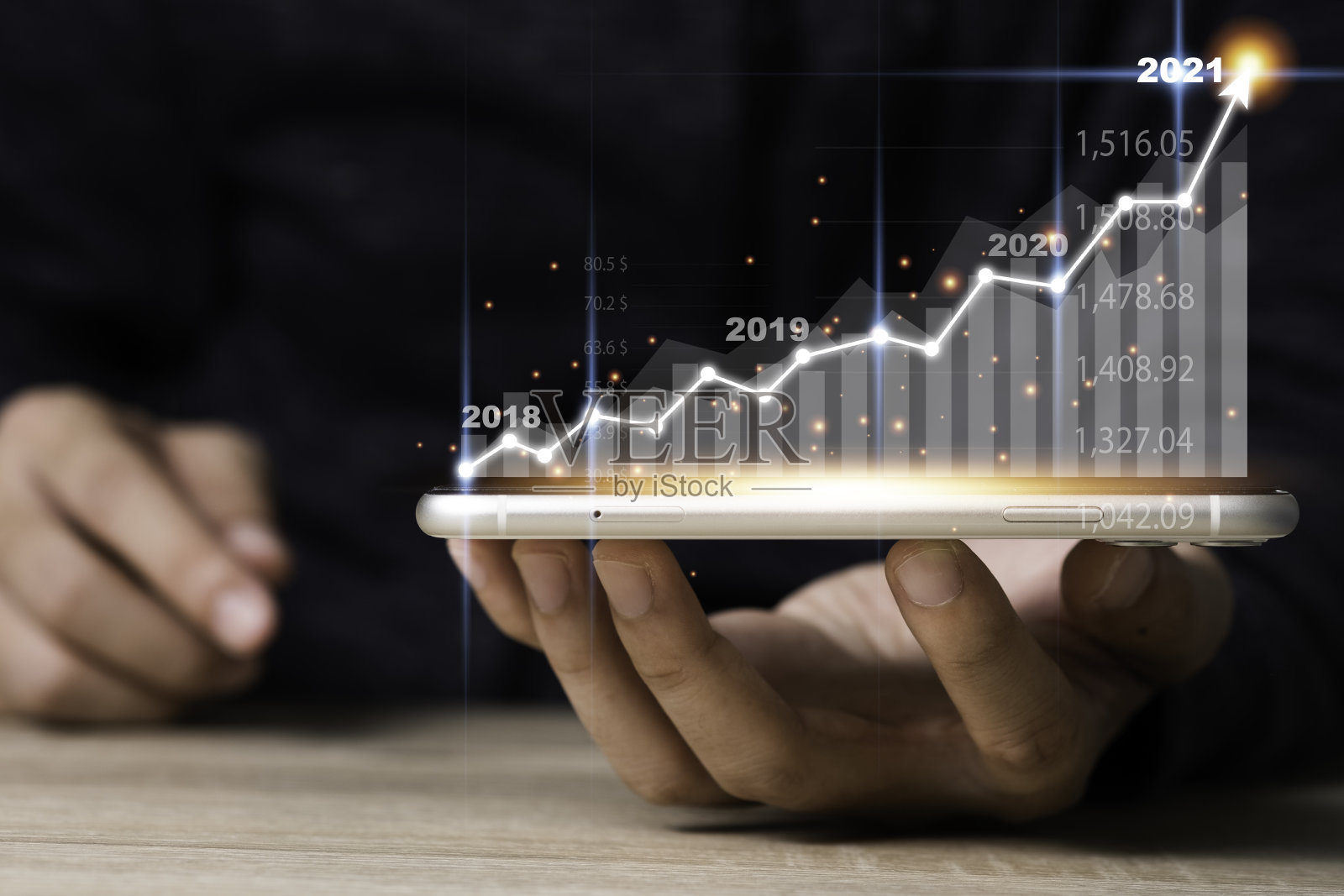 手持手机与虚拟箭头和投资图。业务和利润增长的概念。照片摄影图片