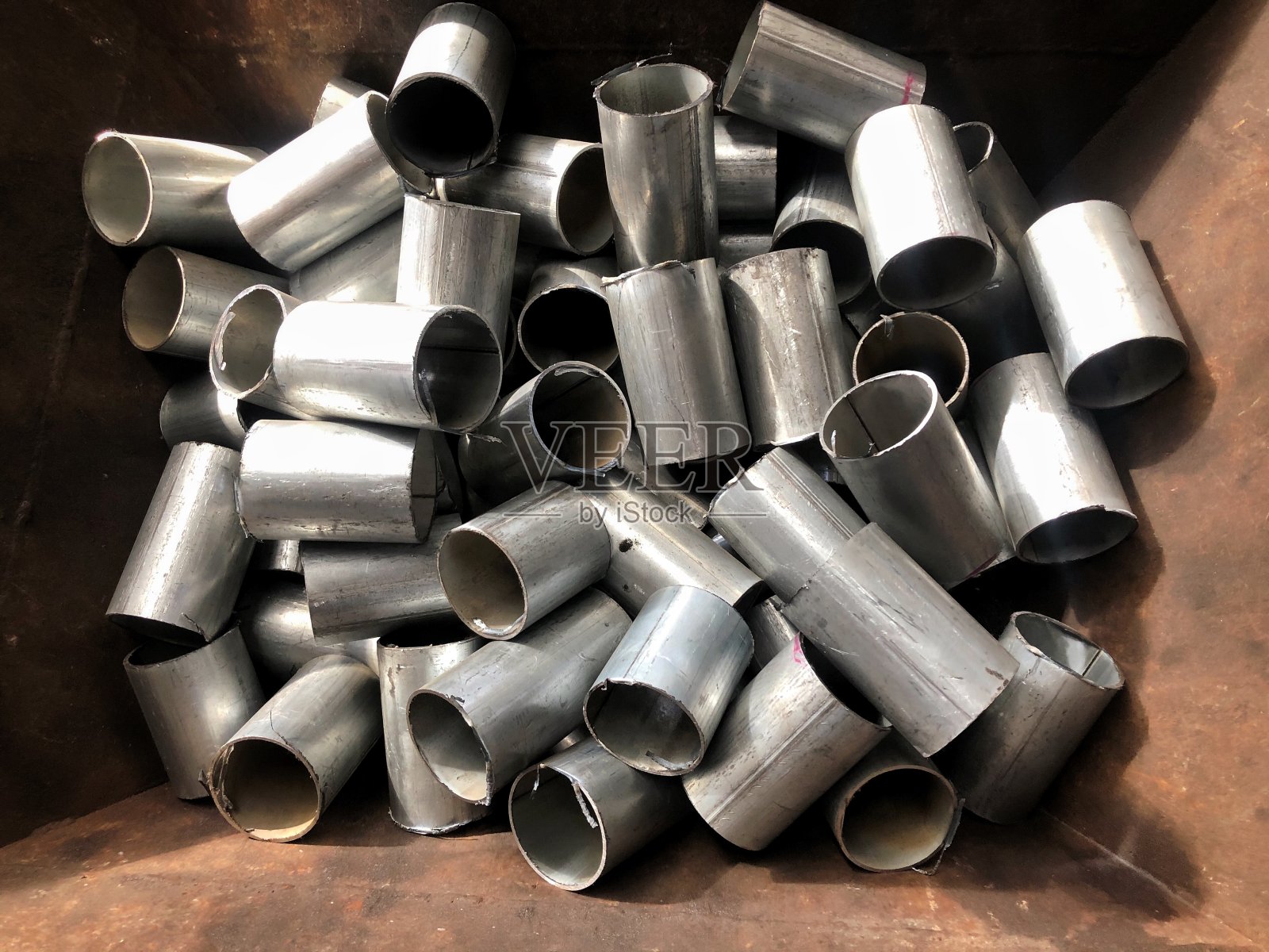 用过的管道堆放在垃圾场，准备回收利用照片摄影图片