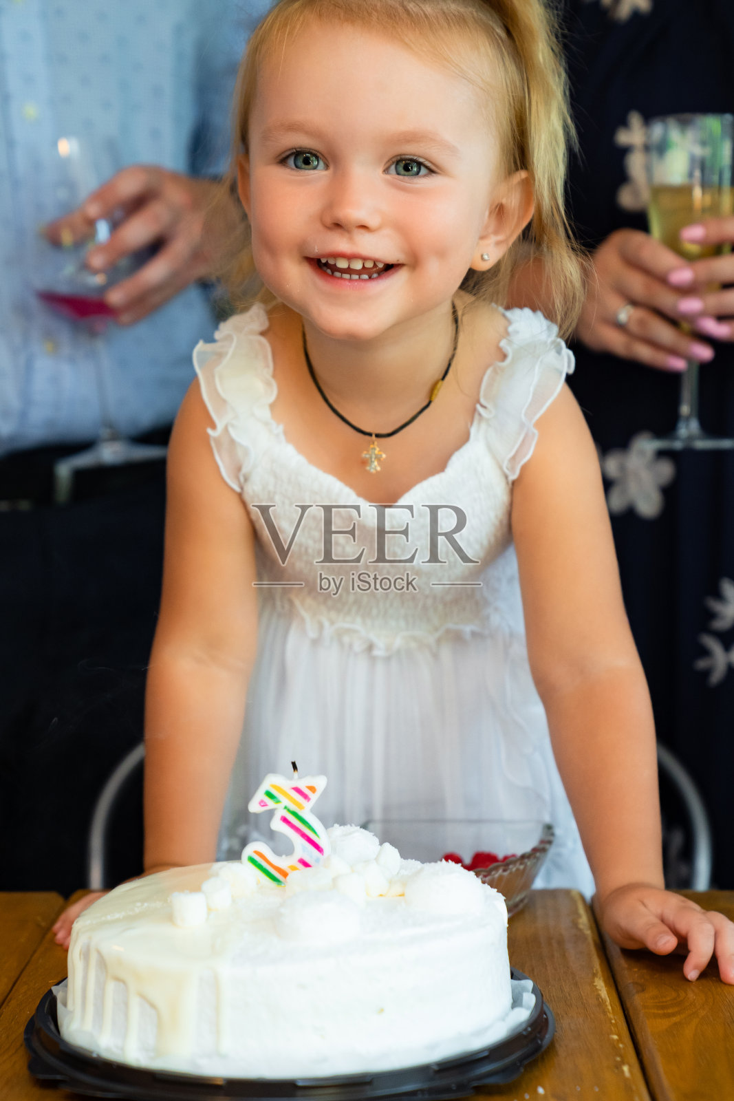 小女孩吹灭生日蛋糕上的蜡烛。照片摄影图片