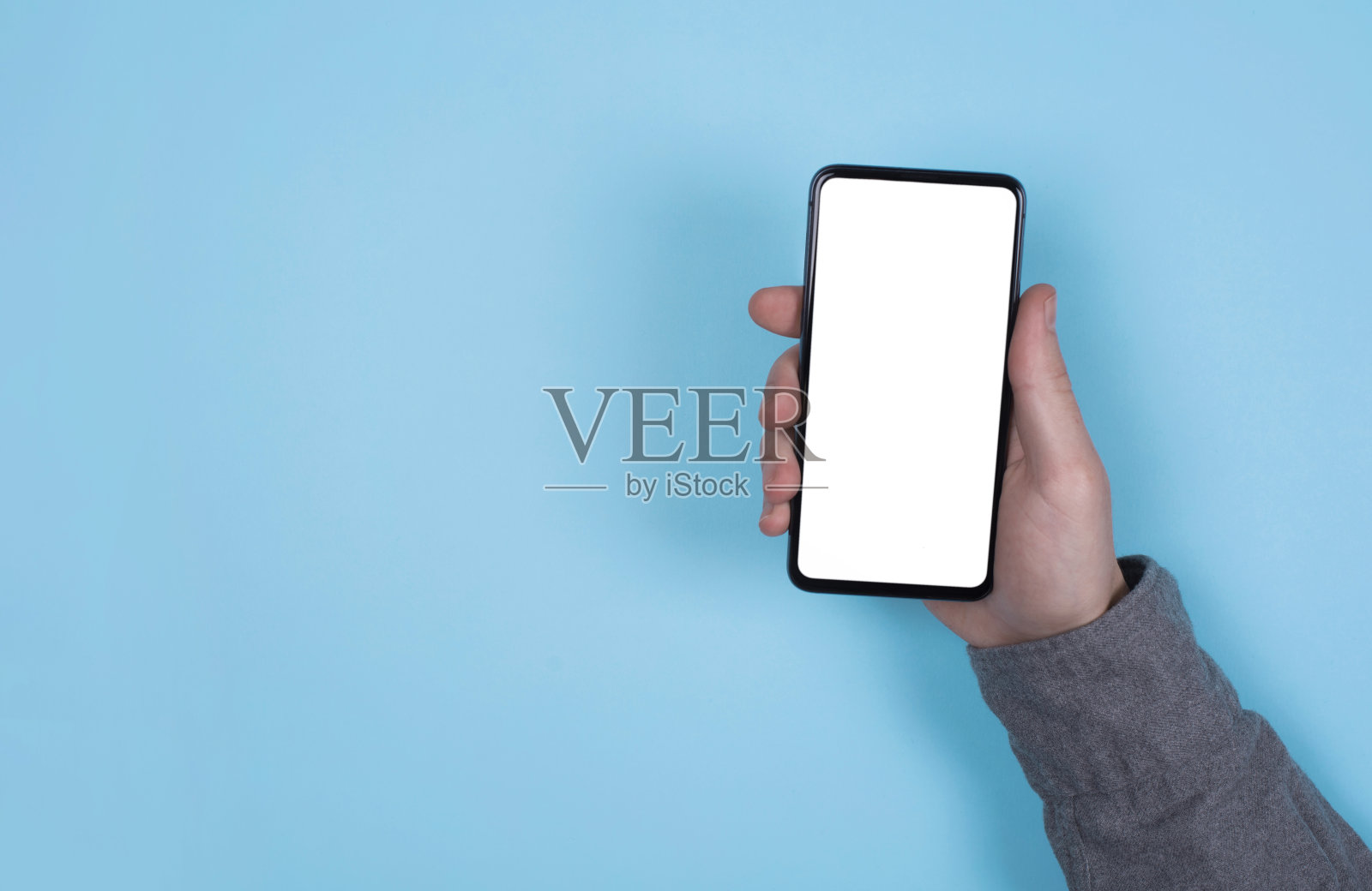 电话在男人手里。蓝色背景。手机的模型。照片摄影图片