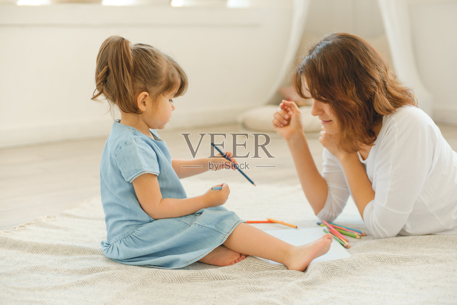 一位年轻的母亲在家里花时间陪她的小女儿。照片摄影图片