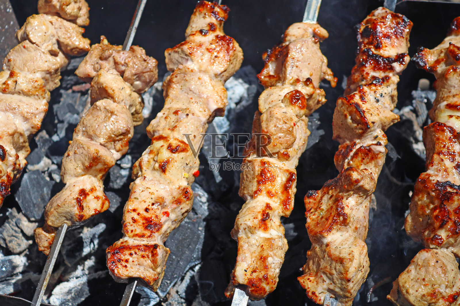 多汁的肉片在明火上煮着照片摄影图片