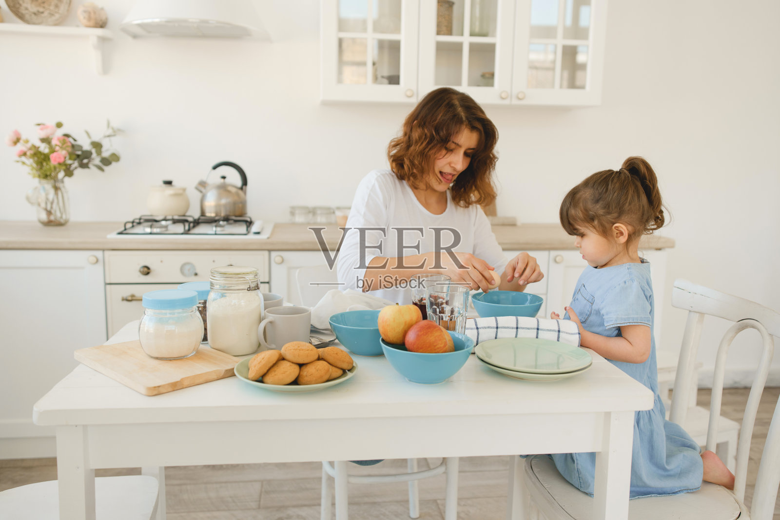 一位年轻的母亲在家里花时间陪她的小女儿。照片摄影图片