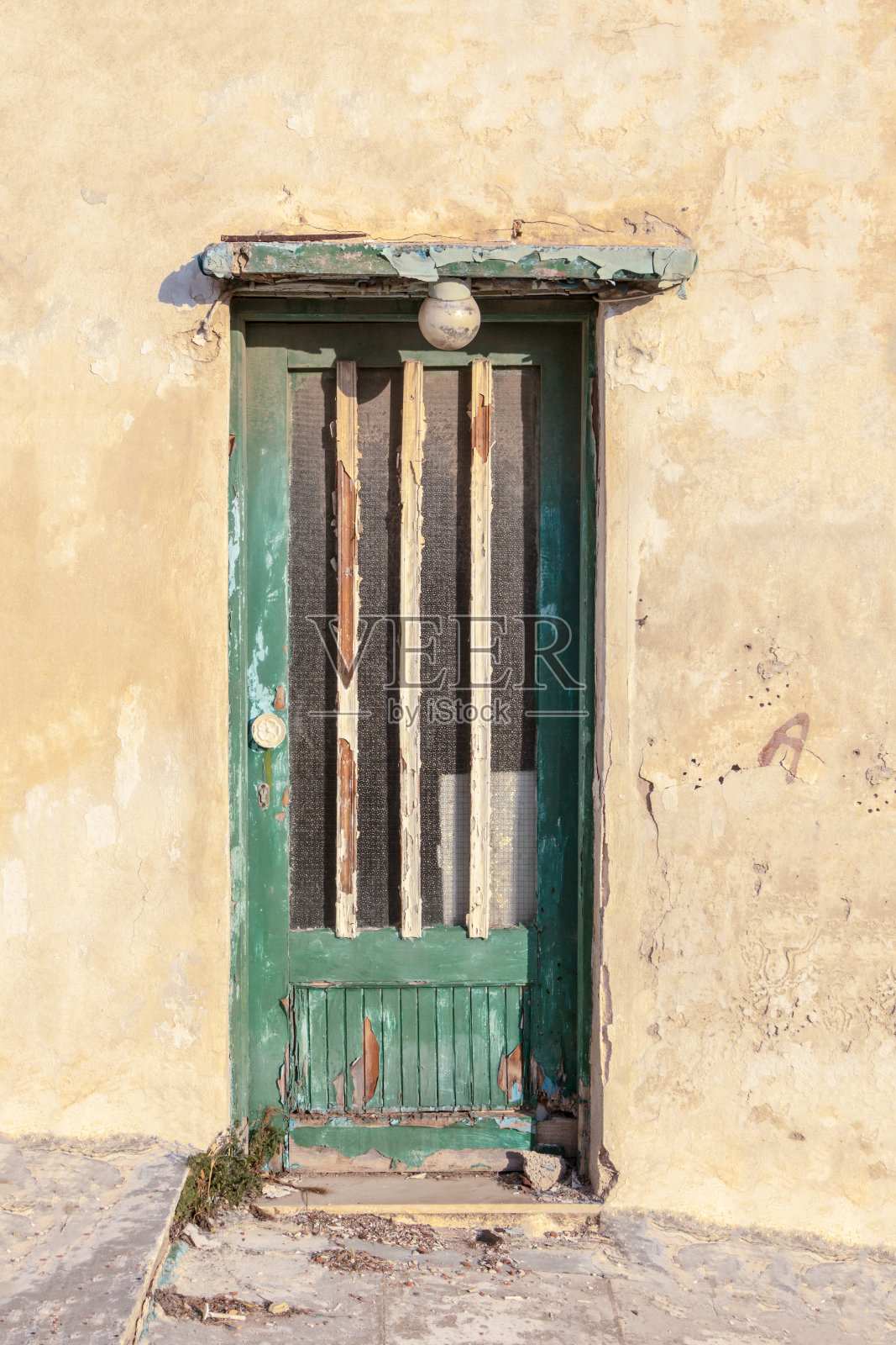 旧木门上的垃圾风化的墙。照片摄影图片