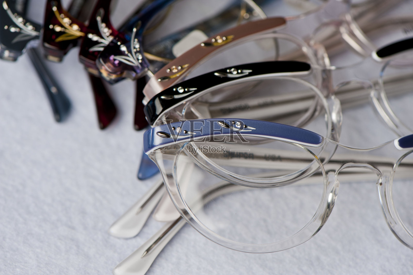 老式的眼镜。各种彩色，充满活力的黑色眼镜和眼镜框架拍摄在彩色和白色的背景。在验光师办公室和眼镜商店可以买到经典的眼镜产品照片。照片摄影图片