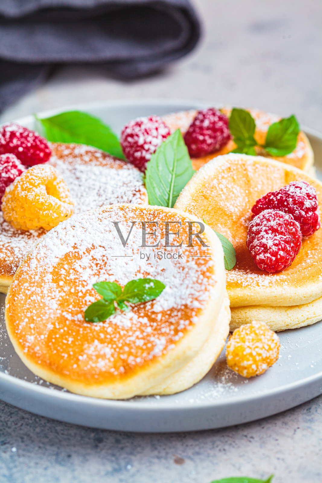 日本松饼和覆盆子灰色的盘子，灰色的背景。日本料理的概念。照片摄影图片