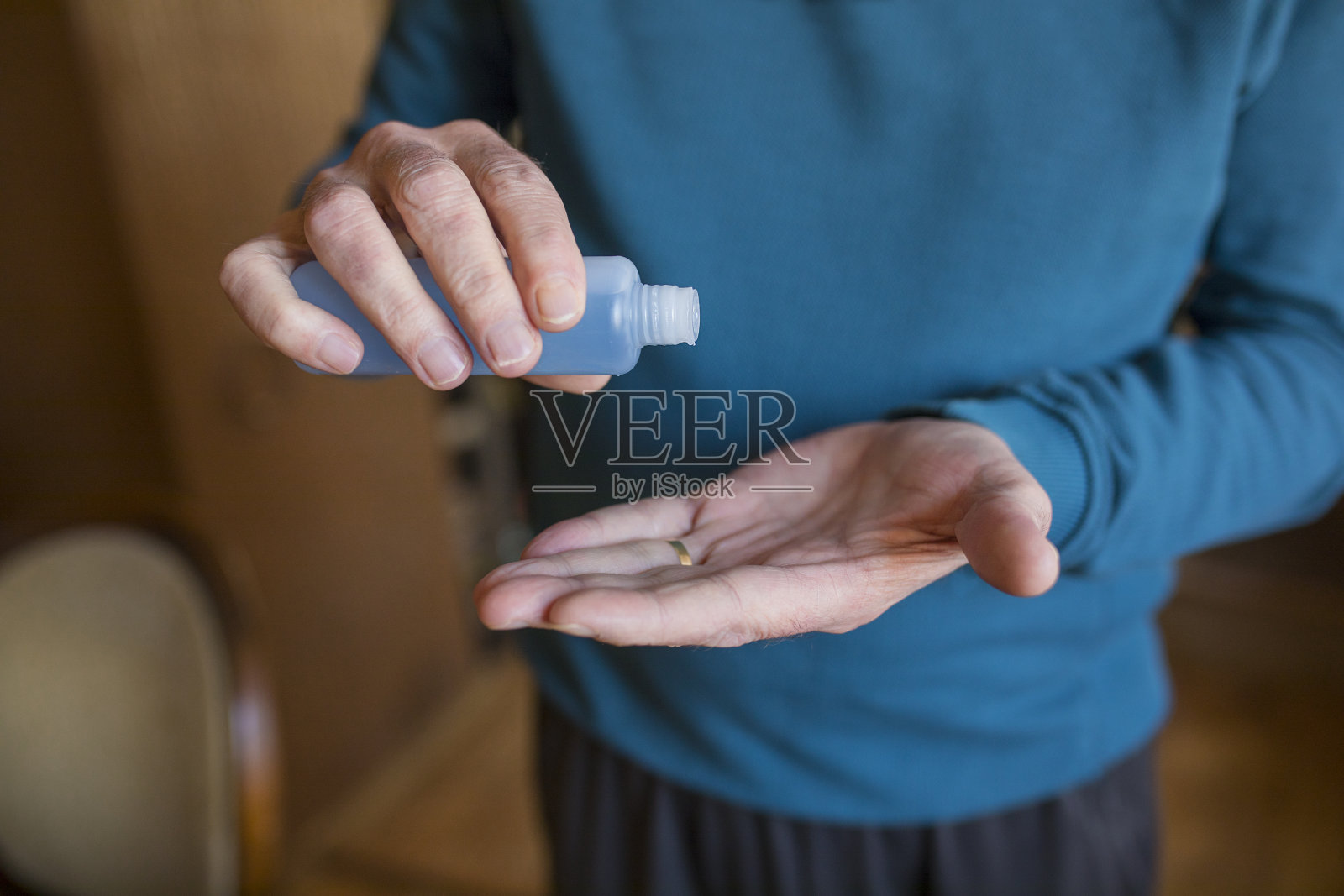 老人正在用洗手液消毒双手照片摄影图片