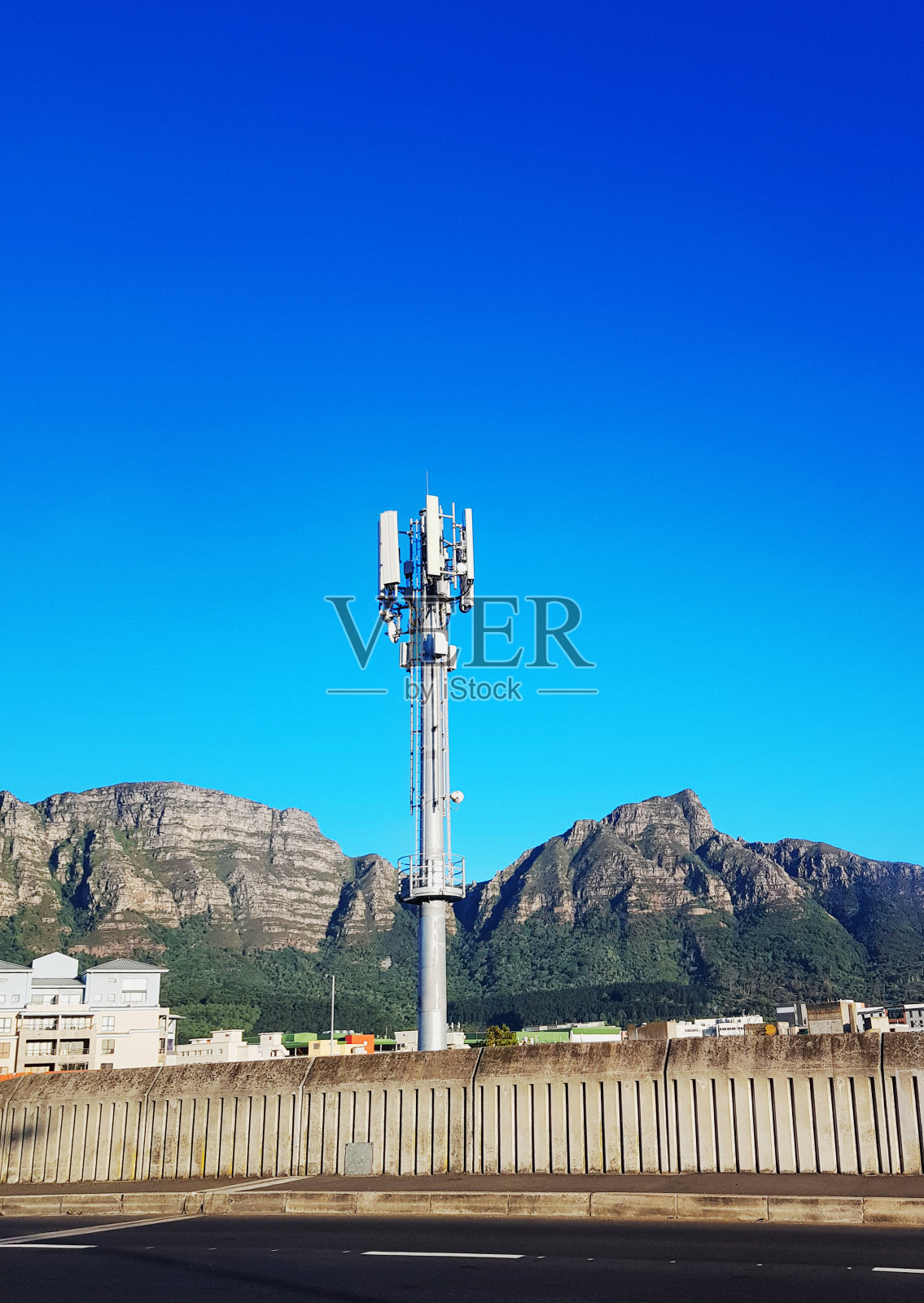 在南非开普敦，一个手机中继塔的桅杆升起，背景是桌山山脉的一部分照片摄影图片