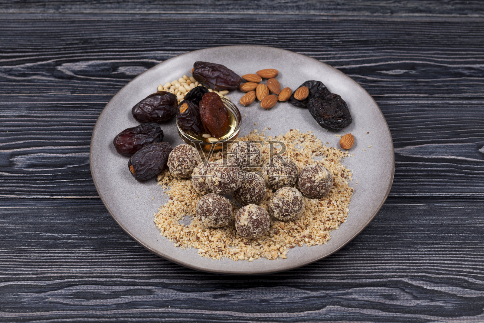 能量球与枣，糖果适当营养自制深色背景。由杏，杏仁，松子和西梅干制成，加蜂蜜。深色木桌，特写，拷贝空间照片摄影图片