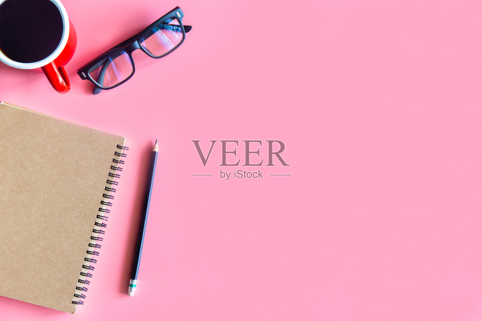 柔和的粉红色办公桌办公室笔记本电脑，智能手机和其他工作用品一杯咖啡。顶视图，带有用于输入文本的复制空间。工作台上的工作台是平面上的基本元素。照片摄影图片