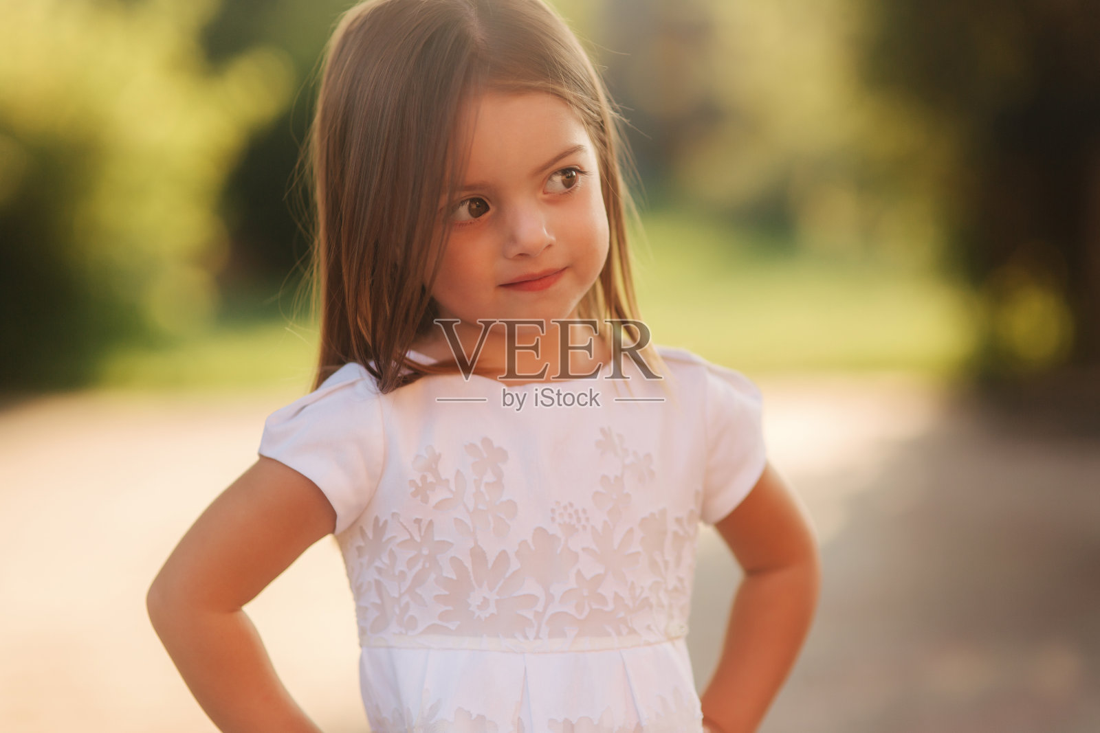 穿着白色连衣裙的小女孩开心地笑着照片摄影图片