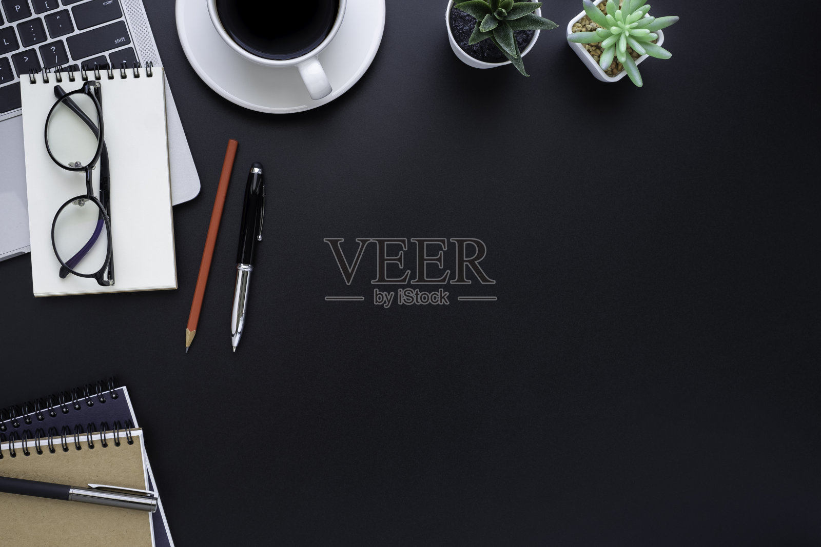 上方俯视黑色办公桌，桌子上有笔记本电脑，笔记本电脑和咖啡杯等办公用品设备。商业和财务概念。工作场所，平躺与空白拷贝空间。照片摄影图片