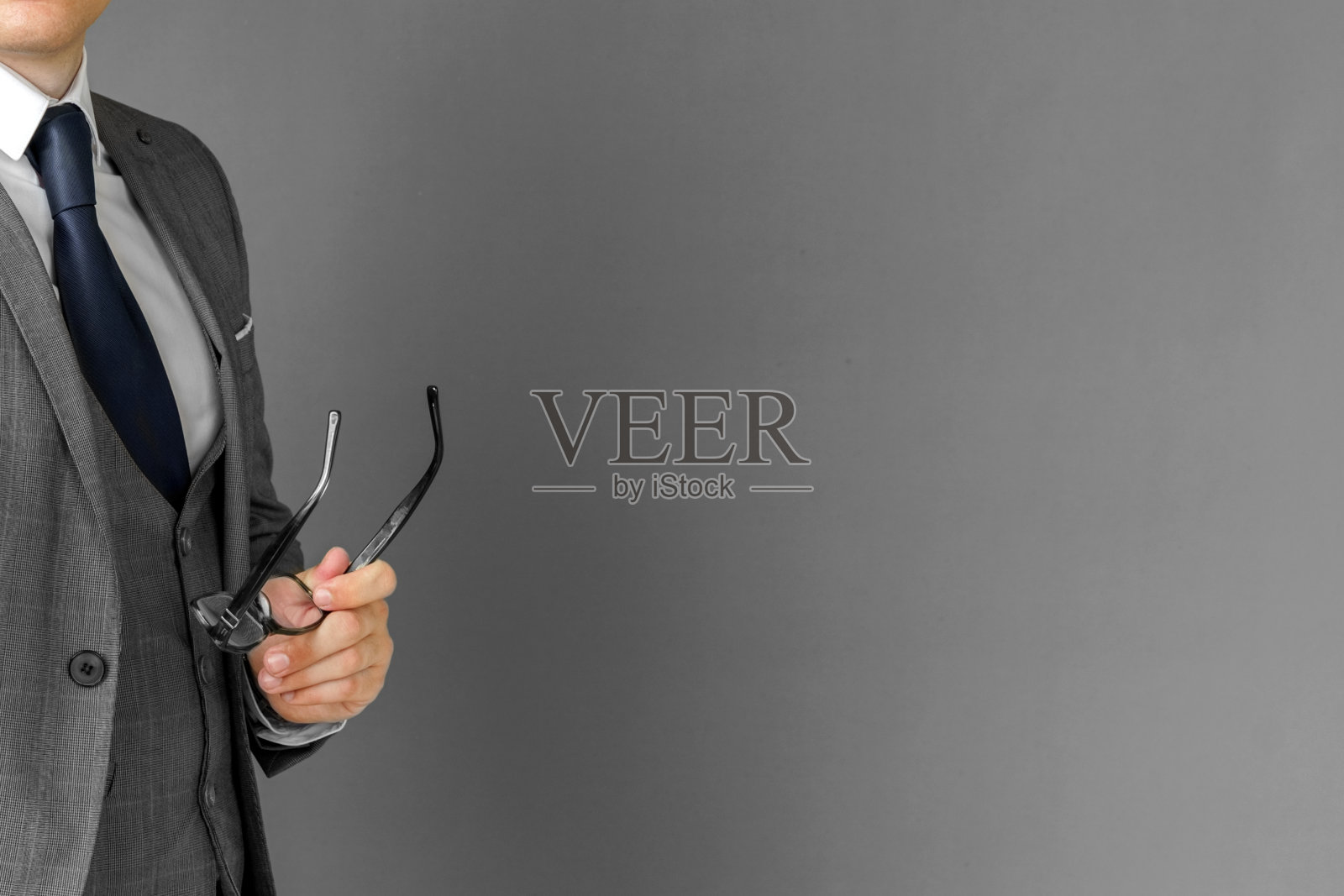 一个西装革履的商人正在调整他的眼镜。脸是不可见的。照片摄影图片