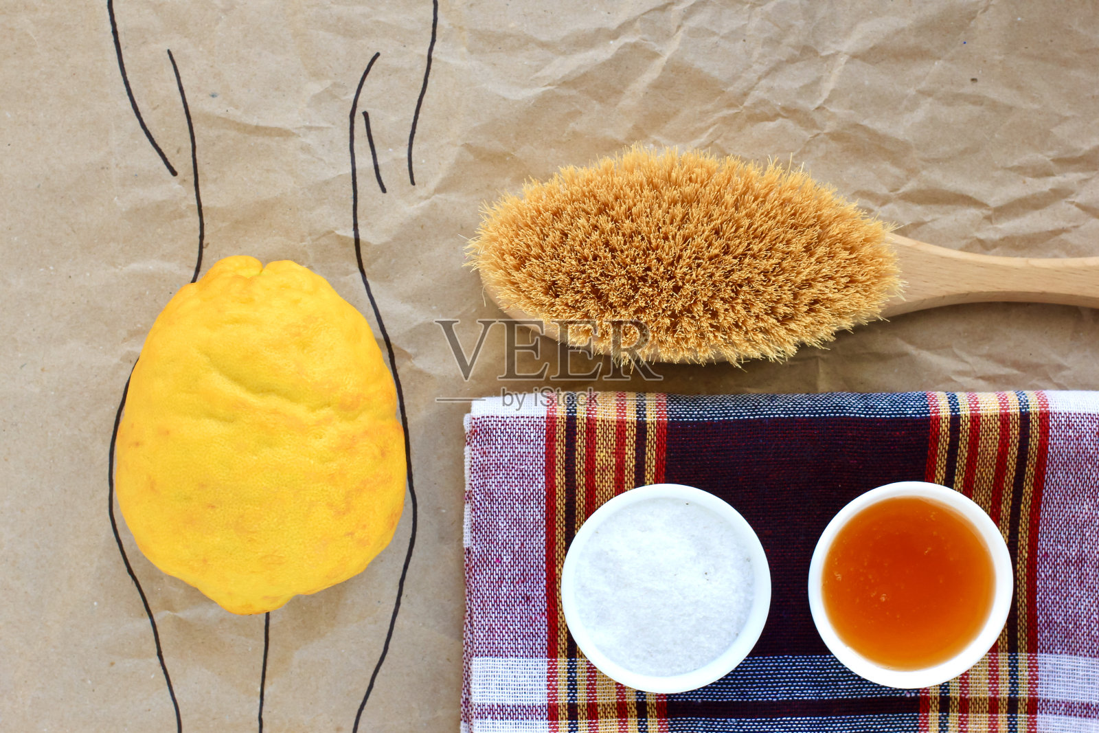 柠檬躺在画好的女性剪影上，在纹理纸的背景上模仿臀部。SPA的概念，身体护理，减肥按摩，抗色素沉着，美容。照片摄影图片