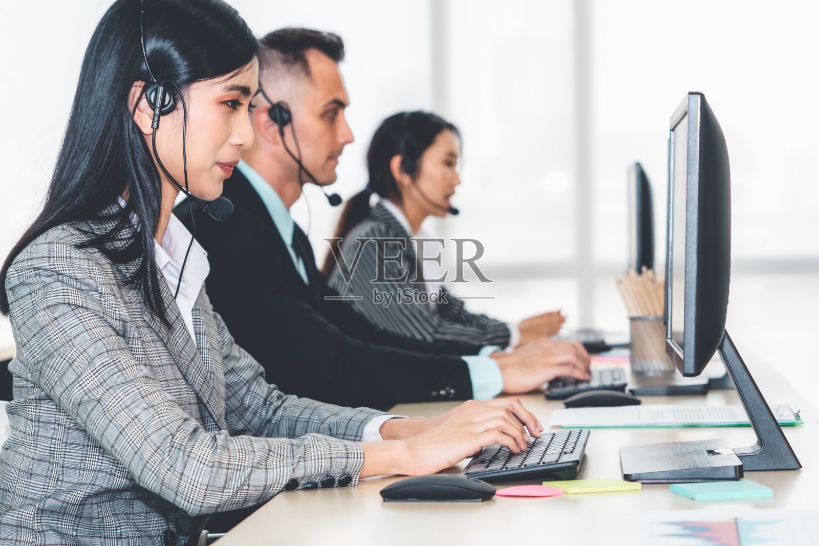 商务人员戴着耳机在办公室工作照片摄影图片