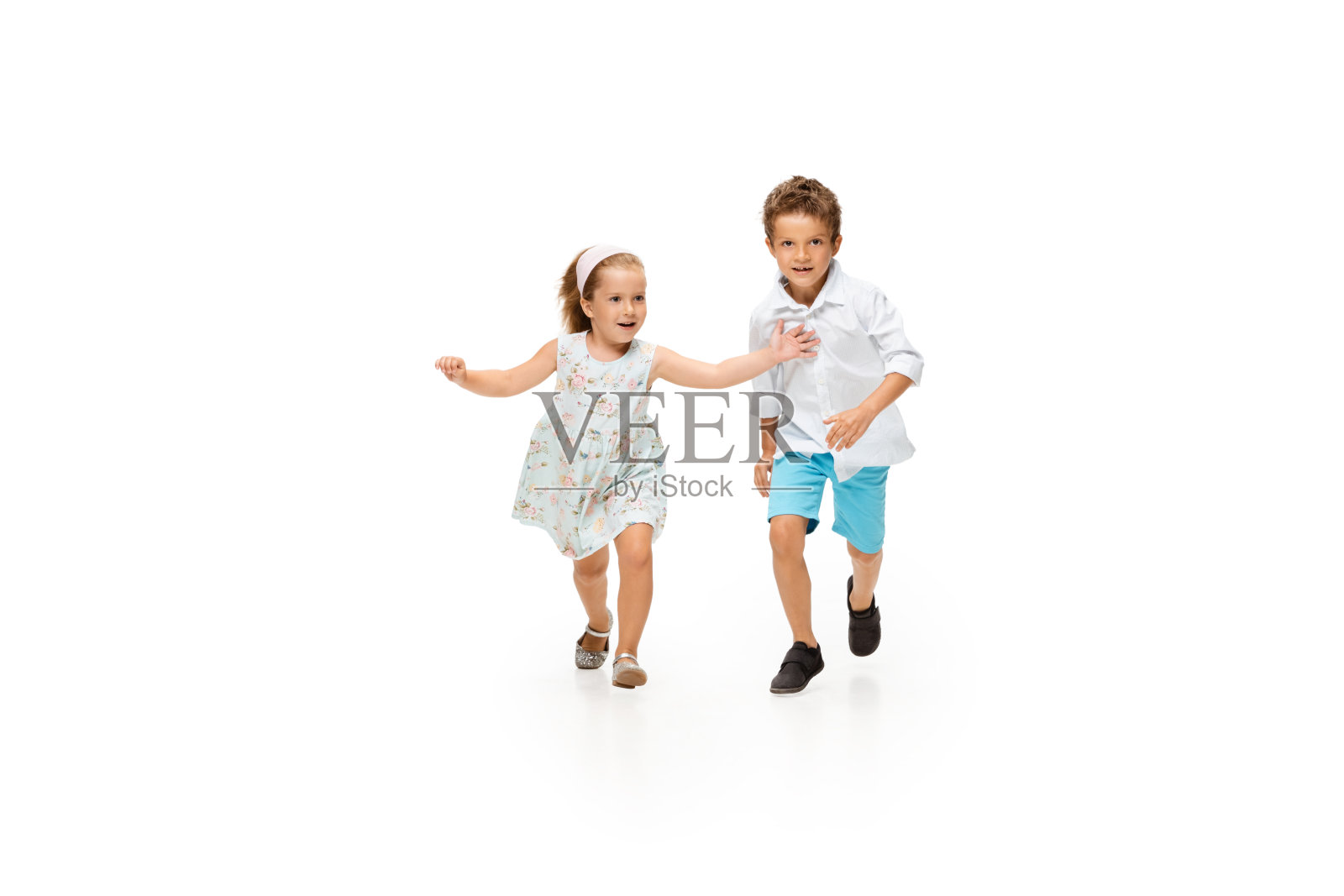 快乐的孩子们，白人小男孩和小女孩在白色的背景上跳跃和奔跑照片摄影图片