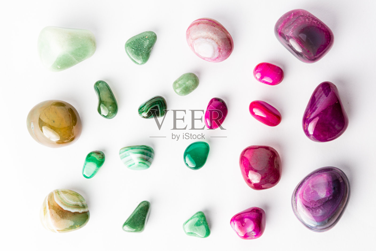 粉红色和绿色的半宝石整齐地排列在白色的背景上照片摄影图片