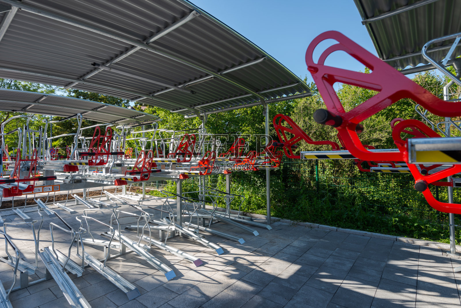 在阳光明媚的日子里，郊区火车站附近有一个崭新的空自行车架，上面有两层供通勤者使用照片摄影图片