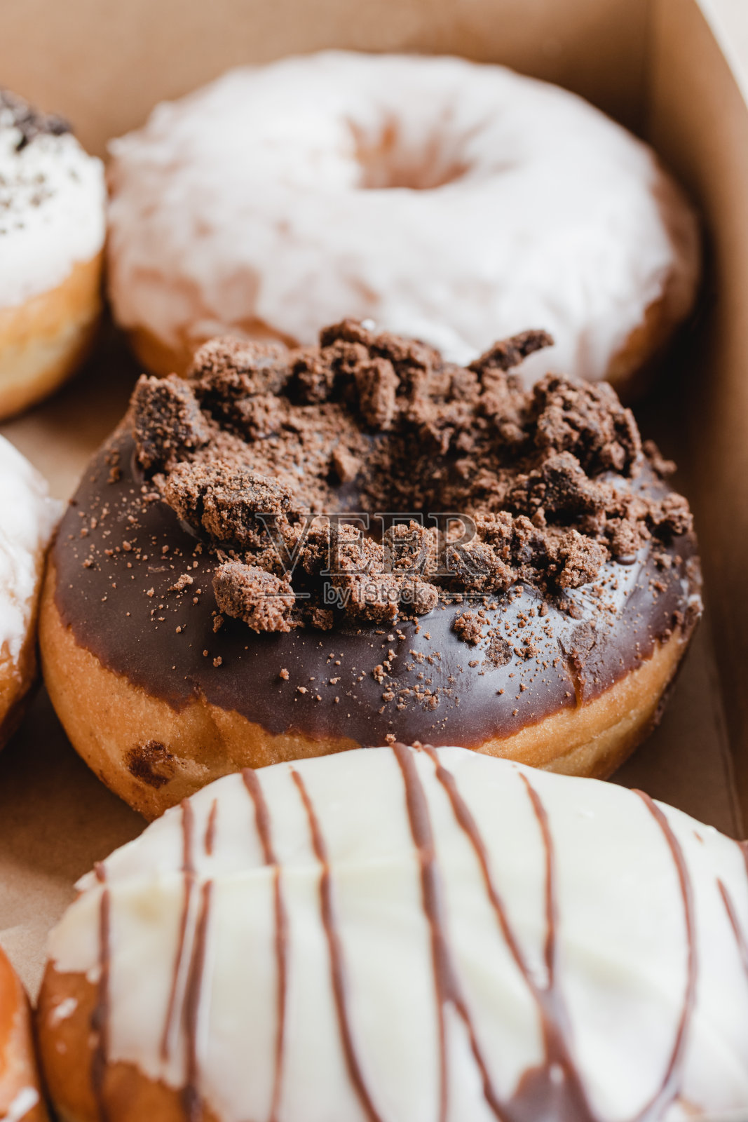 盒子里的巧克力甜甜圈特写。照片摄影图片