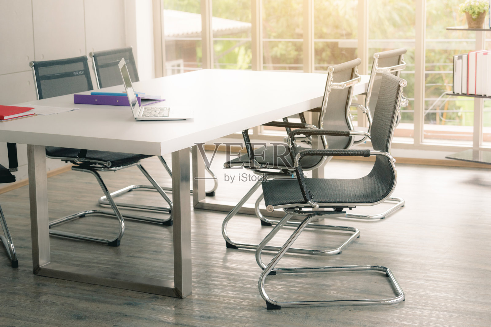 白色会议室的黑色椅子，阳光明媚。照片摄影图片