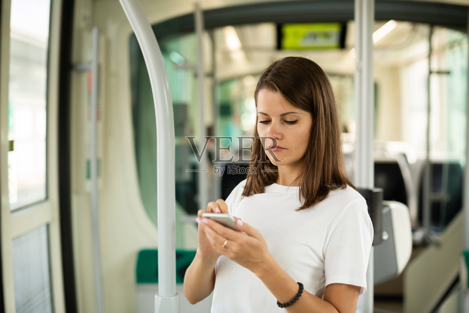 女孩在公共交通工具上使用智能手机照片摄影图片