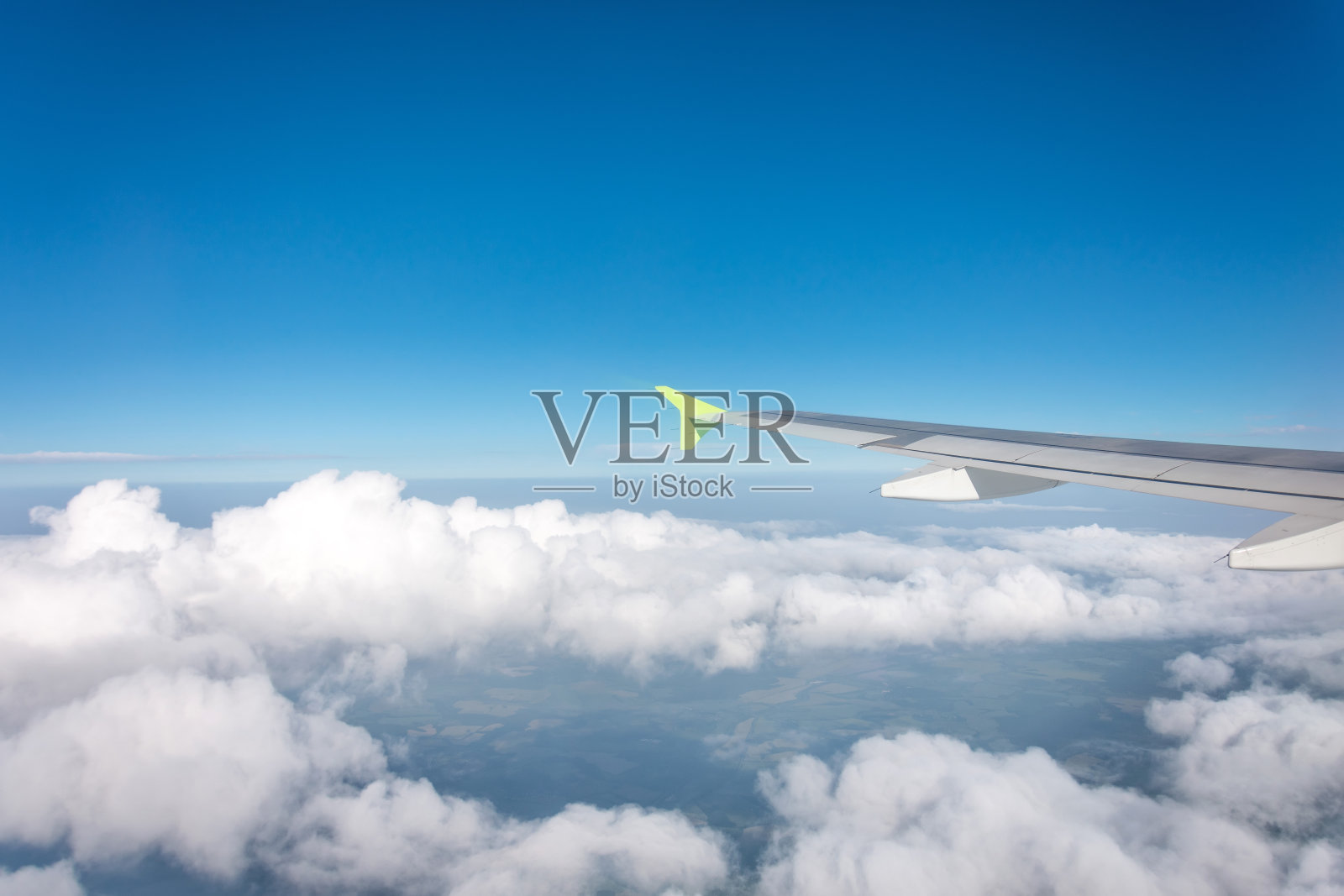 机翼上的飞机的小翼和喷气发动机，蓬松的云在天际线上升飞行水平。照片摄影图片